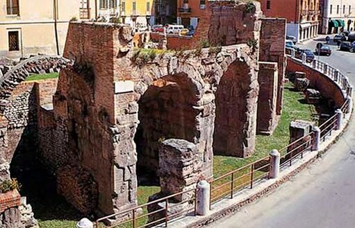 L'Area Archeologica di Interamna Praetutiana a Teramo (TE) rappresenta una delle testimonianze più significative della storia antica della provincia di Teramo. Le origini della città sono avvolte nel mito, con alcune teorie che attribuiscono la fondazione ai Fenici. Questi navigatori, giunti nel territorio, avrebbero chiamato il luogo "Petrut", ossia "luogo elevato circondato dalle acque", gettando le basi per un emporio commerciale che, con il tempo, divenne la capitale del Pretutium con il nome di Interamnia Praetutiorum. Il sito si sviluppava su una lingua di terra delimitata dal fiume Tordino e dal torrente Vezzola, la cui confluenza a est garantiva un ambiente fertile e facilmente difendibile. Il nome Interamnia, derivante dal latino "inter amnes" (tra i fiumi), riflette la particolare posizione geografica della città. Il termine Praetutiorum richiama i Pretuzi, la popolazione italica che abitava la regione. La città fu un importante centro dei Pretuzi nella Regione V menzionata da Plinio il Vecchio, e la sua posizione strategica la rese un nodo fondamentale per i commerci e la comunicazione tra l'entroterra appenninico e la costa adriatica. Con il tempo, Interamnia si dotò di una rete viaria che la collegava a Roma attraverso una strada che attraversava Amiternum e si innestava nella via Salaria. Altri collegamenti permettevano di raggiungere Castrum Novum, Hadria e Asculum, rafforzando il ruolo della città come snodo commerciale e centro di scambi culturali. La costruzione di strade consolari contribuì a potenziare la crescita economica e l'importanza strategica del territorio, favorendo l'integrazione con il mondo romano. Secondo Frontino, la città iniziò come conciliabulum, un centro di aggregazione, per poi ottenere il titolo di municipium. L'antica Petrut, di presunta origine fenicia, si trasformò progressivamente in una città di rilievo, diventando la capitale del Praetutium. Il nome della popolazione locale ha lasciato tracce nella toponomastica attraverso i secoli, con i termini Pretutti, Pretuzzi, Pruzzi, Aprutii, Aprutio, Apruzio e infine Abruzzo, a testimonianza della profonda eredità culturale di questa terra.