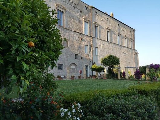 Il Museo Civico di Palazzo d'Avalos a Vasto rappresenta uno dei principali luoghi di cultura della regione Abruzzo. Il palazzo, che si erge maestoso sulla città e affaccia sul mare, è un esempio di architettura rinascimentale abruzzese del tardo Cinquecento. Costruito su strutture precedenti risalenti all'epoca romana e altomedievale, il palazzo ingloba i resti di una fortificazione quattrocentesca eretta dai Caldora e distrutta durante l'incursione turca del 1566. Nel corso dei secoli, sotto la signoria della famiglia d'Avalos, il palazzo acquisì un aspetto regale, arricchendosi di un giardino in stile napoletano che, grazie a un recente restauro, è stato riportato al suo splendore originale. Il giardino, con la sua vista panoramica sul mare, è uno dei punti di maggior fascino del palazzo. All'interno del Museo Civico, il Museo Archeologico è uno dei più antichi d'Abruzzo, essendo stato fondato nel 1849. Le sue collezioni coprono un ampio arco temporale, dall'Età del Ferro al periodo romano e altomedievale, documentando la storia della città di Histonium, l'antica Vasto. Tra i reperti più significativi ci sono i corredi funerari provenienti dalle necropoli del Tratturo e di Villalfonsina, ma anche il celebre sarcofago di Publius Paquius Scaeva, un importante esempio della scultura romana. Accanto a questi reperti, il museo conserva oggetti votivi, come il guerriero offerente con corazza anatomica, che offrono uno spunto per riflettere sulla vita religiosa e culturale dell'antica regione frentana. La Pinacoteca Civica, situata al piano superiore del palazzo, espone le opere dei fratelli Palizzi, una delle famiglie artistiche più rilevanti del XIX secolo. I quattro fratelli, tutti pittori, sono noti per aver contribuito alla nascita della scuola paesaggistica napoletana, entrando in contatto con le nuove tendenze artistiche europee. Tra le opere esposte si trovano dipinti di Filippo Palizzi, il più celebre dei fratelli, come "I due pastorelli", "Olanda" e "Il Muletto", che documentano il suo passaggio da uno stile romantico a un realismo sempre più marcato, basato sull'osservazione diretta della natura. La Pinacoteca ospita anche una sezione dedicata all'arte contemporanea, con opere provenienti dalla collezione Paglione-Olivares, che comprende lavori di artisti italiani e spagnoli, testimoniando la continuità e l'evoluzione della tradizione artistica mediterranea. Il Museo del Costume, creato nel 2000 grazie all'iniziativa del Lions Club Adriatica Vittoria Colonna, rappresenta un altro angolo affascinante di Palazzo d'Avalos. La collezione, che espone abiti e corredi risalenti all'800 e al primo '900, proviene da famiglie vastesi e racconta la storia delle tradizioni sartoriali locali. Oltre ai costumi, la sezione è arricchita da dipinti e litografie di Pier Canosa, che illustrano i costumi tradizionali abruzzesi. Recentemente, il museo ha ampliato la sua offerta con l'aggiunta di nuovi spazi destinati a mostre temporanee, grazie ai lavori di restauro che hanno interessato il Quarto della Marchesa. Con la sua ricca varietà di collezioni, il Museo Civico di Palazzo d'Avalos continua a essere un importante centro di cultura e storia per Vasto e per l'intera regione.