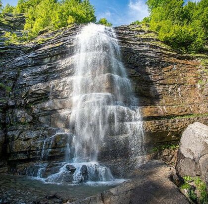 Cascata della Morricana - Fraz. Ceppo di Rocca Santa Maria (Te), Parco Nazionale del Gran Sasso e Monti della Laga. La Cascata della Morricana ha origine dalle acque limpide che sgorgano dalle sorgenti montane dei Monti della Laga, nel Parco Nazionale del Gran Sasso e Monti della Laga. Questo spettacolo naturale si forma grazie al corso d’acqua che scende tra le fitte faggete della frazione Ceppo di Rocca Santa Maria, in provincia di Teramo. Il torrente, alimentato dalle piogge e dallo scioglimento delle nevi, scorre tra gole rocciose e prati rigogliosi prima di precipitare nella spettacolare cascata. Il contesto naturale che circonda la cascata è caratterizzato da una vegetazione rigogliosa, con faggi secolari che offrono ombra e protezione alle numerose specie animali e vegetali presenti. Il Bosco Martese, attraversato dal corso d’acqua, è uno degli ambienti più suggestivi e biodiversi della zona, ricco di funghi, muschi e piante rare che rendono la passeggiata un’esperienza sensoriale unica. Le acque della cascata scorrono impetuose durante la primavera e dopo abbondanti piogge, creando un’atmosfera magica in cui il rumore dell’acqua si mescola ai suoni della natura. La purezza e la trasparenza del torrente conferiscono alla cascata una bellezza incontaminata, mentre la sua portata varia in base alle condizioni climatiche, regalando scenari diversi a seconda delle stagioni. Questo luogo selvaggio è anche habitat di numerose specie animali, tra cui il lupo appenninico, i cervi e l’aquila reale, che nidifica nelle vicinanze. La Cascata della Morricana non è solo una meta escursionistica, ma un simbolo della ricchezza naturalistica dell’Abruzzo, dove la natura si esprime nella sua forma più autentica e spettacolare.