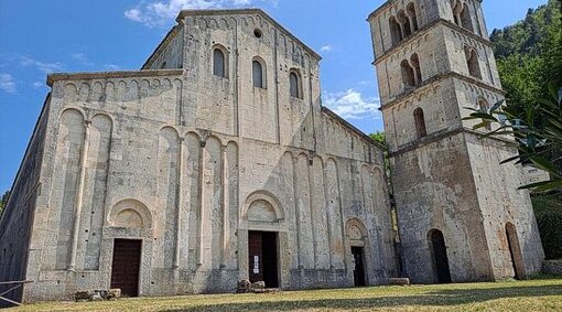 I luoghi sacri in Abruzzo: L’abbazia di San Liberatore a Majella di Serramonacesca. L'abbazia di San Liberatore a Majella di Serramonacesca è un luogo sacro che incarna la profonda spiritualità dell'Abruzzo medievale. Immersa nelle pendici boscose della Majella, la sua storia affonda le radici nell'VIII secolo, quando venne fondata come rifugio di preghiera e meditazione. Nel corso dei secoli, il culto che si sviluppò attorno a questa abbazia divenne un punto di riferimento per la religiosità della regione, contribuendo a radicare una forte tradizione monastica che attraversò il Medioevo. La sua posizione, in armonia con la natura selvaggia circostante, la rese un luogo ideale per coloro che cercavano un contatto più intimo con il divino. Nel XI secolo, l'abbazia assunse la sua forma definitiva, caratterizzata dal puro stile romanico lombardo, che conferisce ancora oggi alla struttura una solennità discreta e una bellezza senza tempo. La chiesa, con i suoi tre portali e il possente campanile, rappresenta un punto di incontro tra la terra e il cielo, tra il sacro e il quotidiano. L'interno, sobrio ma imponente, offre uno spazio perfetto per la meditazione, dove l'arte e l'architettura si fondono in un linguaggio che parla direttamente all'anima. Ogni angolo dell’abbazia richiama alla riflessione e alla preghiera, dal pavimento a opus sectile, che si distingue per la sua bellezza, ai delicati affreschi che adornano le pareti, raccontando storie di fede e devozione. L’abbazia, nel corso dei secoli, ha ospitato numerosi monaci e pellegrini, diventando un centro spirituale di grande importanza. La sua comunità monastica, purtroppo distrutta da una frana causata dal torrente Alento, era una delle più vivaci della regione, contribuendo alla diffusione del culto di San Liberatore. La figura del santo, che si dice abbia avuto una forte influenza sulla spiritualità locale, continuò a essere venerata dai fedeli anche dopo il declino del monastero. La sua memoria è ancora viva tra le rovine, e l'abbazia resta un punto di riferimento per chi cerca una connessione profonda con la tradizione spirituale dell’Abruzzo. Oggi, l'abbazia di San Liberatore a Majella continua a essere un luogo di culto e di pace. Non solo come monumento storico, ma come simbolo di una sacralità che persiste nel tempo. Le sue rovine, pur segnate dal passare dei secoli, conservano intatto il fascino di un luogo dove la natura, l’arte e la fede si incontrano. Visitando l'abbazia, si avverte ancora il respiro di una tradizione monastica che ha attraversato i secoli, testimoniando la resilienza della spiritualità abruzzese e il continuo richiamo alla contemplazione e alla preghiera.