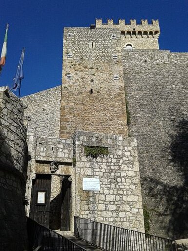 Il Museo di Arte Sacra della Marsica, ospitato all’interno del Castello Piccolomini di Celano, è una delle principali istituzioni culturali della provincia dell’Aquila. Il castello, fondato alla fine del Trecento dalla famiglia Berardi e completato nella metà del Quattrocento dai Piccolomini, rappresenta una cornice ideale per un museo che raccoglie le più importanti testimonianze artistiche della Marsica. Gestito dal Ministero della Cultura attraverso la Direzione Regionale Musei, il museo è stato allestito in collaborazione con la Diocesi dei Marsi e si sviluppa su diverse sale che offrono un percorso immersivo nell’arte sacra del territorio. Le sale del museo custodiscono una vasta collezione di opere che spaziano dal VI al XVIII secolo, espressione delle tradizioni artistiche locali e delle influenze che la Marsica ha ricevuto nel corso dei secoli. Tra le opere più rilevanti, troviamo dipinti, sculture, oreficeria e tessuti che raccontano la vita religiosa e la spiritualità della regione. Il percorso espositivo si articola in modo da mettere in evidenza non solo le opere di grande valore artistico, ma anche le tecniche e i materiali utilizzati dagli artisti per raccontare la devozione e la fede delle comunità marsicane. Tra i capolavori esposti, spiccano la "Crocifissione di Gesù" della scuola di Vincenzo Foppa, una tela che riflette l’influenza delle scuole lombarde in Abruzzo, e il busto di Madonna, datato intorno al 1440 e attribuito al pittore Andrea De Litio, considerato una delle sue prime opere. Altra opera di grande significato è la croce astile di Cese, risalente al XIV secolo, simbolo di devozione religiosa. Il museo ospita inoltre una ricca collezione di dipinti di stile bizantino, insieme a numerose Madonne con bambino, opere che testimoniano l'evoluzione dell’arte sacra in Abruzzo durante il Medioevo. Oltre al valore artistico, il Museo di Arte Sacra della Marsica è anche un luogo di grande rilevanza storica e culturale. Esso offre ai visitatori l’opportunità di esplorare la storia religiosa della regione attraverso le sue opere d’arte, che raccontano il legame profondo tra la comunità locale e la spiritualità. Il museo non si limita ad essere uno spazio di conservazione, ma è anche un punto di riferimento per la valorizzazione della cultura religiosa e artistica del territorio, diventando un polo di attrazione per appassionati d’arte e studiosi, ma anche un luogo in cui riscoprire e vivere la storia di una delle regioni più affascinanti dell'Abruzzo.