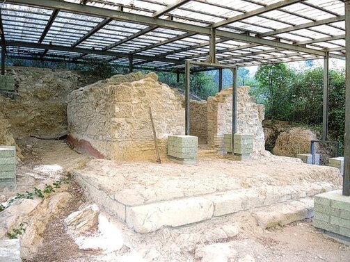Il Sito Archeologico di Montebello, situato nel comune di Montorio al Vomano in provincia di Teramo, è un importante punto di interesse per gli appassionati di archeologia e storia antica. Il sito ospita i resti di un tempio dedicato a Ercole, risalente al periodo romano, che testimoniano l'importanza della zona nel panorama religioso e culturale dell'epoca. Per raggiungere il sito, si percorre un sentiero che scende verso il fiume Vomano e, dopo averlo guadato, si risale per un breve tratto in un campo incolto. Il tempio si trova in località Venaquila, a poca distanza dal centro abitato, lungo la strada statale 80 del Gran Sasso d'Italia. Scoperto nel 1865 dall'archeologo Felice Barnabei, il tempio di Ercole è uno dei monumenti più significativi della regione. La datazione del tempio è stata possibile grazie a un’iscrizione trovata nel pavimento a mosaico, che menziona la coppia consolare dell'anno 55 a.C. Questo ritrovamento ha confermato l'importanza del sito come punto di riferimento lungo la via Cecilia, una delle principali arterie di collegamento tra Roma e le province dell'Italia centrale. Il tempio di Ercole, insieme ad altri templi nelle vicinanze, faceva parte di un complesso sistema di edifici religiosi costruiti dai Romani per consolidare il loro controllo sul territorio. Nel corso dei secoli, il tempio fu abbandonato a causa di una frana che danneggiò parte della struttura, ma che, al contempo, ha contribuito a preservare le rovine. Le mura della cella del tempio sono ancora visibili, e all’interno si conserva una pavimentazione a mosaico in opus tessellatum, con tessere bianche e nere che formano riquadri geometrici. Questi resti sono tra i più importanti del sito e offrono uno spunto significativo per comprendere l'arte e l'architettura religiosa romana. L'iscrizione sul mosaico, che attesta la dedicazione del tempio a Ercole, è un elemento fondamentale per il suo studio e per la comprensione del contesto storico e culturale dell'epoca. Per garantire la conservazione del sito, le rovine sono state coperte da una tettoia che protegge il mosaico e gli altri resti archeologici dalle intemperie. Oggi, il sito archeologico di Montebello rappresenta una risorsa preziosa per gli studiosi di archeologia, ma anche un luogo affascinante per i visitatori interessati alla storia romana. Grazie ai resti del tempio di Ercole e agli altri reperti rinvenuti nella zona, il sito offre uno spunto per esplorare la religiosità, l'architettura e la vita quotidiana degli antichi Romani, nonché il legame profondo che esisteva tra l'uomo e la natura nel contesto della cultura romana.