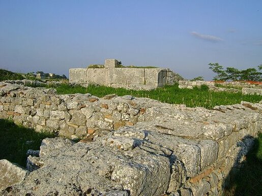 Il sito archeologico di Juvanum, situato nella frazione Fonticelle a Montenerodomo (Ch), è un importante esempio di insediamento che ha visto il passaggio da una fase sannitica ad una romana. Originariamente abitata sin dall'età del bronzo, la città di Juvanum subì una trasformazione radicale dopo le guerre sannitiche, entrando a far parte dell'orbita romana. Con il suo status di municipio romano, la città venne arricchita dalle tipiche infrastrutture e monumenti che caratterizzavano i centri urbani di Roma, diventando un punto di riferimento per la regione. Nell'acropoli di Juvanum, uno degli elementi più significativi è il complesso templare, costituito da due templi adiacenti. Questi edifici religiosi furono costruiti inizialmente dalla tribù sannita dei Carecini e successivamente dedicati a divinità romane, come Eracle, Diana, Vittoria e Minerva. Il tempio maggiore, risalente all'inizio del II secolo a.C., è il più antico e conserva parte del perimetro e del podio. Il tempio minore, di poco successivo, ha visto conservato solo il podio, ma rappresenta comunque un'importante testimonianza del culto romano nella città. A piedi dell'acropoli si trova il teatro, una struttura che testimonia l'importanza culturale e sociale della città nel periodo romano. La scena e parte della cavea sono ancora ben conservate, insieme alla pavimentazione del foro. Qui, le basi delle statue rinvenute fanno luce sul contesto religioso e politico di Juvanum, come nel caso delle epigrafi onorarie che associano le statue di Minerva e di Cornelia Salonina, moglie dell'imperatore Gallieno, che dimostrano la connessione della città con l'élite romana. Il parco archeologico di Juvanum offre una straordinaria opportunità di immergersi nella storia, permettendo di osservare da vicino come la città, inizialmente un insediamento sannitico, si sia evoluta e trasformata sotto l'influenza romana. I resti archeologici, che spaziano dai templi alle strutture pubbliche, raccontano un passato ricco di culture che si sono fuse, lasciando un'eredità unica e affascinante per chi visita il sito oggi.