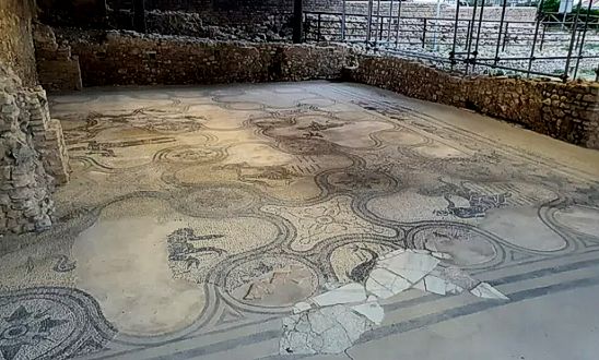 Le terme di Histonium, oggi situate a Vasto, rappresentano uno dei siti archeologici più importanti e meglio conservati dell'Abruzzo. Il complesso termale, che risale al II secolo d.C., fu scoperto nel 1974 grazie a scavi che rivelarono una parte consistente dell'antica struttura. Sebbene alcune aree rimangano ancora sepolte, la maggior parte delle strutture e dei mosaici è stata riportata alla luce, offrendo uno spaccato straordinario della vita romana. Tra le scoperte più significative c'è il famoso mosaico di Nettuno, che si estende su una superficie di 170 m² e raffigura il dio del mare con un tridente e un delfino, simboli del suo dominio. Il mosaico di Nettuno è senza dubbio il pezzo più famoso del sito e rappresenta una delle opere artistiche più complesse dell'epoca romana. Accanto al dio, vi sono raffigurazioni di cavalli e tritoni, tutte realizzate con grande maestria. Il pavimento a mosaico che lo ospita è composto da tessere bianche, nere e marroncine, ed è uno degli esempi migliori di come l'arte romana potesse fondere estetica e funzionalità. Le decorazioni mitologiche, che includono animali marini e creature fantastiche, sono una testimonianza della cultura popolare e religiosa del tempo, nonché della maestria degli artigiani che lavoravano nei laboratori di Histonium. Nel complesso termale sono stati rinvenuti anche altri mosaici e strutture che testimoniano l'importanza della città durante il periodo romano. Histonium, infatti, era una città fiorente e ben organizzata, che doveva la sua ricchezza alla posizione strategica e alle sue risorse naturali. La scoperta delle terme ha permesso di ricostruire parte della vita quotidiana dei suoi abitanti, che frequentavano questi luoghi non solo per motivi igienici, ma anche come centri di incontro e socializzazione. Le terme facevano parte di un più ampio progetto urbano, che comprendeva anche l'anfiteatro e il sistema di distribuzione dell'acqua, elementi fondamentali per la vita nella città romana. Oggi le terme di Histonium sono un'importante attrazione turistica e culturale, visitabile soprattutto durante la stagione estiva, ma anche in altri periodi dell'anno su richiesta. Oltre alla bellezza dei mosaici, il sito offre uno spunto interessante per approfondire la storia di Vasto e del suo sviluppo attraverso i secoli. Grazie agli scavi, è possibile immergersi in una realtà romana che ha lasciato un'impronta indelebile sul territorio, non solo con le sue strutture monumentali, ma anche con l'arte che ne ha arricchito gli spazi pubblici.
