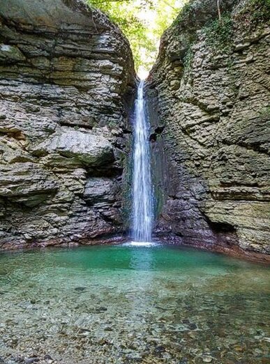 Le Cascate dei fiumi in Abruzzo: Cascate del Torrente Cusano - Roccamorice (Pe), Parco Nazionale della Majella. Per arrivare alle Cascate del Torrente Cusano, situate nel Parco Nazionale della Majella, è necessario percorrere un sentiero naturale non segnalato, che ti condurrà in uno degli angoli più suggestivi della Majella. Il percorso, seppur breve, si sviluppa attraverso una zona selvaggia e incontaminata, dove il paesaggio montano offre scenari affascinanti e panorami mozzafiato. Il cammino porta fino all’incredibile canyon scolpito dalle acque del Torrente Capo la Vena, un luogo dove la natura ha creato uno spettacolo di formazioni rocciose e cascate. Dopo aver attraversato il canyon, si arriva alla Cascata Cusano, conosciuta anche come la Cascata del Lejo, un angolo di natura incontaminata. Il percorso è di media difficoltà e può risultare impegnativo, soprattutto per chi non è esperto di escursionismo, dato che non ci sono sentieri segnalati. La zona è difficile da percorrere, quindi è consigliato avere esperienza di montagna o, in alternativa, essere accompagnati da guide esperte. La bellezza del luogo e la tranquillità che si respira ripagano ampiamente lo sforzo, ma è importante essere preparati per affrontare il terreno irregolare e la mancanza di indicazioni precise. Le Cascate del Torrente Cusano sono una meta ideale per chi cerca un po' di refrigerio durante le calde estati italiane. Il sentiero attraversa una fitta boscaglia e si immerge in una gola caratterizzata da una vegetazione pluviale, con alberi che offrono ombra e frescura. L'acqua cristallina del torrente che scorre tra le rocce è un invito irresistibile a fermarsi e godersi la bellezza del paesaggio. L’atmosfera è quella di un angolo paradisiaco, dove la natura regna sovrana e offre un'opportunità di relax lontano dalla frenesia quotidiana. La Cascata Cusano è facilmente raggiungibile in auto, a soli 40 minuti da Pescara e circa un’ora e quaranta minuti da L'Aquila. Questo la rende una meta perfetta per una gita di un giorno, alla scoperta di un angolo selvaggio e poco conosciuto dell'Abruzzo. La cascata rappresenta uno dei luoghi più belli della regione, dove è possibile godere della natura in totale autonomia, senza l'affollamento delle mete turistiche più famose. Se si è alla ricerca di un'esperienza autentica, immersi in un paesaggio incontaminato e mozzafiato, le Cascate del Torrente Cusano sono una destinazione imperdibile.