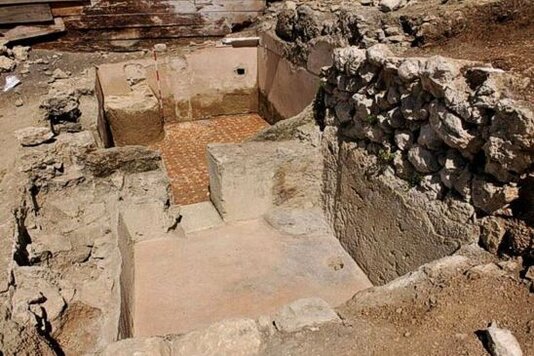 Il sito archeologico di Alfedena, situato tra Castel di Sangro e Alfedena, offre importanti testimonianze dell'epoca sannitica, con numerosi rinvenimenti di vici e necropoli in diverse aree del territorio. Scavi effettuati in località come Campo Consolino, Campo Dragone e Pianizze hanno portato alla luce resti significativi di questi insediamenti antichi. La principale area fortificata si trova nella "valle del Curino", un sito che conserva ancora tratti delle mura in opera poligonale, un edificio pubblico chiamato "Basilica" e un piccolo tempio. Questi edifici, risalenti a un periodo successivo alla conquista romana, testimoniano la trasformazione del luogo durante l'epoca imperiale e la continuazione della vita religiosa e civile nella regione. La necropoli di Campo Consolino è uno degli elementi più rilevanti del sito archeologico, avendo restituito circa 1500 sepolture. Gli scavi condotti da Lucio Mariani alla fine dell’Ottocento e successivamente dalla Soprintendenza Archeologica hanno rivelato una sistemazione interna delle tombe che non appare casuale. Le sepolture sono disposte in gruppi irregolari ma strutturati, indicativi di clan familiari. Il periodo di utilizzo della necropoli si colloca tra la fine del VI e la fine del IV secolo a.C., offrendo un’importante visione delle pratiche funerarie dei Sanniti e della loro organizzazione sociale. Il periodo romano ha lasciato significativi resti nel sito, tra cui ritrovamenti nell'area di contrada Campitelli, dove si ritiene fosse il foro cittadino. Le iscrizioni rinvenute in questa zona suggeriscono la presenza di un macellum e di strutture destinate ai ludi degli Augustali. Ulteriori scavi hanno portato alla luce resti di un edificio preromano, che è stato successivamente inglobato nelle strutture romane, situato dietro la chiesa di San Nicola. Le scoperte fatte negli anni Trenta del Novecento hanno anche rivelato edifici sacri nel foro del municipium di Aufidena, indicando l'importanza dei culti religiosi nel contesto cittadino romano. Ercole, la divinità sannitica più venerata, è documentato in diversi santuari del sito, testimoniato dai rinvenimenti di statuette bronzee raffiguranti l’eroe. Il santuario principale dedicato a Ercole si trova lungo la riva sinistra del fiume Sangro, presso i ruderi del convento di Santa Maria di Cinquemiglia. Altri santuari extraurbani, come quello di Casadonna, sono stati individuati grazie agli scavi. Nella zona meridionale di Castel di Sangro, sono stati rinvenuti i resti di un edificio romano, interpretato come un tempio, e i resti di una domus risalente ai primi periodi dell'insediamento romano. Questo ampio patrimonio archeologico testimonia l'importanza storica e culturale di Alfedena e della sua evoluzione dall'epoca sannitica a quella romana.