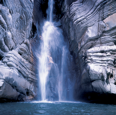 Le Cascate dei fiumi in Abruzzo: Cascata del Caccamo – Gole del Salinello – Civitella del Tronto (Te). La Cascata del Caccamo si trova nel cuore delle Gole del Salinello, un incantevole angolo del Parco Nazionale dei Monti della Laga, nel comune di Civitella del Tronto, in provincia di Teramo. Questo territorio selvaggio, con i suoi paesaggi suggestivi, è ideale per chi cerca un contatto diretto con la natura incontaminata. Per raggiungere la cascata, si parte da Ripe, un borgo pittoresco famoso per la Grotta di Sant'Angelo, e si segue un sentiero ben segnalato che attraversa la zona. Il percorso, pur essendo relativamente breve, presenta alcune difficoltà che richiedono l'uso di corde posizionate lungo il tragitto, offrendo così un'esperienza escursionistica unica. La cascata, che si tuffa da un’altezza di 35 metri, si riversa in un bacino naturale, conosciuto come "lu caccheme," termine dialettale che si riferisce al tegame o alla pentola bassa. Le pareti rocciose che contornano la cascata sono dimora di rapaci come l’aquila reale, mentre la vegetazione che cresce lungo le rive è ricca e variegata, con esemplari di carpino nero, orniello, frassino maggiore e salici, oltre a piante rare come il verbasco a fiori viola. L’ambiente è un perfetto esempio di ecosistema montano incontaminato, che regala a chi lo visita un'esperienza di totale immersione nella natura. Proseguendo lungo il sentiero, è possibile scoprire un angolo nascosto, dove piccole cascate si uniscono per formare piscine naturali di acqua cristallina, ideali per una sosta rinfrescante. Questi piccoli specchi d’acqua, alimentati dal flusso del fiume Salinello, offrono una tranquillità che rende questo luogo ancora più magico. L’acqua limpida e fresca, anche durante i mesi estivi, è un invito irresistibile per chi desidera immergersi nella bellezza naturale e ricaricare le energie. Infine, il percorso prosegue fino ad arrivare alle Grotte del Salinello, un luogo che offre uno spettacolo naturale incredibile. Il canyon, dalle pareti ripide e imponenti, è il rifugio ideale per molte specie di fauna selvatica, rendendo l'area ancora più suggestiva. La Cascata del Caccamo, con la sua bellezza e il suo ambiente selvaggio, rappresenta una delle destinazioni più affascinanti e nascoste dell'Abruzzo, dove la natura e la storia si fondono in un paesaggio mozzafiato.