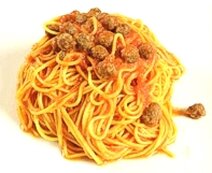 La preparazione dei "Maccheroni alla chitarra con le pallottine" inizia con la realizzazione della pasta, un'operazione che richiede pazienza e maestria. Per preparare i maccheroni alla chitarra, si utilizza farina di semola di grano duro, un ingrediente tipico della tradizione abruzzese, che garantisce una pasta consistente e rustica. L'acqua, una risorsa preziosa delle montagne abruzzesi, viene aggiunta lentamente alla farina fino ad ottenere un impasto compatto e omogeneo. Una volta lavorato, l'impasto viene steso e tagliato attraverso la chitarra, uno strumento che, grazie ai suoi fili sottili, conferisce alla pasta la tipica forma quadrata e ruvida, perfetta per raccogliere il sugo. Nel frattempo, si preparano le pallottine, piccole polpette di carne che sono il cuore del piatto. La carne, tipicamente mista di manzo e maiale, proviene dalle campagne teramane, dove i pascoli sono ricchi di erbe naturali. Alla carne si aggiungono pane raffermo imbevuto di acqua, formaggio pecorino abruzzese grattugiato e uova fresche, anch'esse provenienti dalle aziende agricole locali. Questo impasto viene modellato in piccole palline, che verranno successivamente cotte nel sugo, arricchendo il piatto con il loro sapore intenso. Il sugo che accompagna i maccheroni è preparato con pomodori freschi, raccolti nelle campagne abruzzesi, che sono noti per la loro dolcezza e sapore intenso. In una pentola, si fa soffriggere cipolla e aglio, entrambi prodotti tipici dell’area, con olio extravergine d’oliva, anch'esso di produzione locale. Una volta che il soffritto è ben dorato, si aggiungono i pomodori, che vengono lasciati cuocere lentamente, con l'aggiunta di sale e pepe a piacere. Il sugo deve essere ricco e corposo, in grado di avvolgere perfettamente la pasta. Una volta che i maccheroni sono cotti e scolati, vengono uniti al sugo e alle pallottine. La carne si cuoce lentamente nel sugo, permettendo ai sapori di amalgamarsi perfettamente. Il piatto finale è una combinazione di tradizione e sapori autentici, dove ogni ingrediente racconta una storia di terre montuose e di campi coltivati con passione. Il pecorino, il pomodoro, l'olio e la carne creano un equilibrio perfetto, che fa di questa ricetta uno dei capisaldi della cucina teramana e abruzzese.