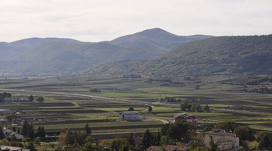 Trekking negli Altopiani e Pianori in Abruzzo: Fare trekking nell’Altopiano di Navelli. L'Altopiano di Navelli, situato tra le maestose catene montuose del Gran Sasso d’Italia e del Sirente-Velino, rappresenta uno dei paesaggi più affascinanti dell'Abruzzo aquilano. A un'altitudine di circa 700 metri, l’altopiano si estende tra dolci colline, campi di zafferano e borghi storici, diventando una meta ideale per gli amanti del trekking e della natura incontaminata. Il borgo di Navelli, che dà il nome all'intera piana, è il centro principale della zona ed è inserito tra i Borghi più belli d’Italia. I sentieri che attraversano il territorio conducono alla scoperta di scenari mozzafiato e di un patrimonio storico e culturale che affonda le radici nella tradizione contadina e pastorizia del territorio. Il trekking nell'Altopiano di Navelli offre l'opportunità di immergersi in un paesaggio ricco di storia, natura e tradizioni. I sentieri che percorrono la piana, spesso su tracce dell'antico Tratturo Magno, conducono alla scoperta di borghi medievali come Caporciano, Prata d’Ansidonia e San Pio delle Camere, ognuno con la sua storia e le sue tradizioni da raccontare. Lungo il cammino, i visitatori possono ammirare chiese romaniche, castelli diroccati e altri luoghi di culto che testimoniano la secolare presenza umana in queste terre. L’altopiano è anche famoso per i suoi campi di zafferano, che in autunno si tingono di viola, offrendo uno spettacolo unico e inaspettato che arricchisce ulteriormente l’esperienza del trekking. Oltre ai sentieri storici, l'Altopiano di Navelli offre anche una varietà di paesaggi naturali che variano dal verde delle colline al giallo delle terre coltivate. In primavera e estate, la zona si trasforma in un mosaico di colori, con campi di fiori selvatici che esplodono in una varietà di sfumature. Il paesaggio si alterna tra le praterie e le colline, offrendo ampi panorami sulle vette circostanti, tra cui il Gran Sasso e il Sirente. La bellezza di questo territorio risiede anche nella sua semplicità, che si rivela in ogni angolo, tra una distesa di fagi e i piccoli borghi che si adagiano sulle colline. I percorsi permettono di percorrere lunghe distanze in tranquillità, godendo di un contatto diretto con la natura. I borghi dell'Altopiano di Navelli, che hanno un legame profondo con la transumanza, raccontano storie di antiche tradizioni legate alla pastorizia e alla coltivazione dello zafferano. A Bominaco, nel comune di Caporciano, si trovano il castello medievale e l’Oratorio di San Pellegrino, che custodisce affreschi unici, tra cui il Calendario Bominacese, un vero capolavoro dell’arte medievale. Prata d’Ansidonia ospita il sito archeologico di Peltuinum, un'antica città vestina che fu conquistata dai Romani, e il borgo fortificato di Castel Camponeschi, che è oggi in fase di ristrutturazione. Ogni borgo dell’altopiano ha la sua storia da raccontare, con monumenti che testimoniano il passaggio delle civiltà e l’evoluzione di un territorio che ha saputo conservare la sua autenticità nel tempo. Fare trekking nell'Altopiano di Navelli significa vivere un’esperienza immersiva in un luogo che conserva la sua bellezza e il suo fascino senza tempo. Ogni passo lungo i suoi sentieri rivela una nuova scoperta, che sia un paesaggio mozzafiato, una roccia secolare o una chiesa romanica nascosta tra gli alberi. Lontano dalla frenesia delle città, questo angolo di Abruzzo offre l’opportunità di ritrovare il contatto con la natura e con le tradizioni, in un viaggio che unisce sport, storia e cultura in un’unica esperienza indimenticabile.