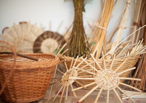 La produzione di cesti e intrecci in Abruzzo è una delle espressioni più antiche e affascinanti dell’artigianato tradizionale, legata da sempre alla vita rurale e ai mestieri legati alla natura. Gli artigiani abruzzesi, con mani esperte e un'intensa conoscenza dei materiali naturali, realizzano cesti, panieri e altri oggetti utilizzando vimini, giunchi e paglia. Ogni pezzo, che può sembrare semplice, è il risultato di un lavoro paziente che richiede precisione e cura dei dettagli, come se ogni intreccio raccontasse una storia di tradizione e saperi antichi, tramandati di generazione in generazione. Le tecniche di intreccio vengono apprese sin da giovani e vengono perfezionate con il tempo. La lavorazione del vimini e degli altri materiali naturali è delicata: ogni fibra deve essere trattata con attenzione per essere modellata in forme che siano sia funzionali che esteticamente piacevoli. Questo artigianato non è solo un mestiere, ma una vera e propria arte che sa unire l’utilità alla bellezza, realizzando oggetti che hanno un legame profondo con la terra e la natura circostante. I cesti che ne derivano sono leggeri ma robusti, pratici e, al tempo stesso, ricchi di una bellezza rustica che è in grado di arricchire ogni ambiente. Ogni cesto e oggetto intrecciato è il frutto di una sapienza antica che gli artigiani abruzzesi continuano a preservare con passione. Nonostante l’evoluzione dei tempi, questi oggetti mantengono il loro valore e la loro funzionalità, adattandosi ai gusti moderni senza mai perdere la loro autenticità. La lavorazione di questi materiali si fa ancora oggi in piccole botteghe e laboratori che sono veri custodi di una tradizione che affonda le radici nelle montagne e nelle campagne dell’Abruzzo. La bellezza e la forza di questi oggetti risiedono proprio nel fatto che non sono prodotti in serie, ma ogni creazione è unica, frutto di un processo manuale che sa donare a ciascun pezzo una propria identità. La tradizione di produzione di cesti e intrecci in Abruzzo non è solo un richiamo al passato, ma una pratica che continua a essere apprezzata anche nel mondo contemporaneo. I cesti, una volta strumenti essenziali per la vita quotidiana, oggi sono apprezzati anche come oggetti decorativi o come regali di alta qualità. La bellezza e la semplicità di questi prodotti artigianali riescono a resistere alla modernità, rimanendo un simbolo di un mestiere che si è adattato ai tempi ma non ha mai perso il legame con la sua tradizione. Gli artigiani abruzzesi, quindi, continuano a raccontare la loro terra attraverso le mani, i materiali e i gesti che permettono di mantenere viva una tradizione che arricchisce la cultura locale e affascina chiunque la scopra.