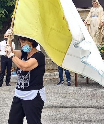 Il Ballo dell'Insegna a Forcella di Teramo è una tradizione che affonda le radici nella devozione religiosa e nelle antiche usanze popolari. Ogni 23 settembre, i cittadini si riuniscono nella piazza del paese per celebrare Maria Santissima della Misericordia, protettrice della comunità. La manifestazione avviene al termine dei riti religiosi e segna il culmine di una giornata dedicata alla Madonna. Il momento centrale della festa è rappresentato dalla danza, un ballo che coinvolge tutta la comunità in un’atmosfera di grande partecipazione e spiritualità. La piazza diventa così il palcoscenico di una tradizione che unisce il sacro e il profano in un rito che si ripete ogni anno, portando con sé il ricordo di secoli di storia e fede. Il protagonista del ballo è l'"Insegna", una bandiera bipartita, gialla e bianca, che viene portata in piazza dall'Alfiere, o "Presidente", accompagnato dagli armigeri e dai suonatori. Quando il corteo arriva in piazza della Caldaia, i partecipanti si dispongono in cerchio, pronti a dare inizio alla danza. L'Alfiere, impugnando l'Insegna, si inginocchia al centro della piazza, baciando il lembo della bandiera prima di alzarla in segno di devozione. La danza inizia poi con il Presidente che, dopo aver mostrato la sua abilità nel far roteare la bandiera senza farla cadere, invita altri "Pretendenti" a partecipare. Il ballo prosegue in un susseguirsi di avvicendamenti spontanei, con ogni danzatore che prova a mantenere l'Insegna sollevata e a compiere una serie di movimenti agili. Il Ballo dell'Insegna è una danza esclusivamente maschile, che racchiude in sé una combinazione di elementi religiosi e di esibizione fisica. La prova di abilità che consiste nel far roteare la bandiera senza farla toccare terra è un atto che mette in risalto la forza fisica e la destrezza dei partecipanti. Oltre ad avere una valenza religiosa, legata alla penitenza e al voto, il ballo è anche un’esibizione di virilità e un rito di iniziazione. Per i giovani, partecipare al ballo rappresenta un’occasione di affermazione sociale, mentre per gli uomini più anziani è un momento per consolidare il loro status e il loro prestigio all'interno della comunità. La partecipazione a questa danza rafforza il legame tra le generazioni e permette di perpetuare una tradizione che è al contempo un atto di devozione e un'esibizione di forza. Le origini storiche del Ballo dell'Insegna sono avvolte nel mistero, ma secondo una tradizione locale, il ballo sarebbe nato in seguito a un miracolo attribuito alla Madonna. Si racconta che un signorotto del paese, ammalato di peste, fu guarito per intercessione della Madonna, apparsa in sogno. In segno di gratitudine, il signorotto avrebbe partecipato alla danza insieme al popolo, dando vita alla tradizione che si celebra ogni anno. Un elemento che sembra confermare questa versione è l'usanza, ancora presente fino a pochi decenni fa, di inginocchiarsi verso il castello al termine del ballo, come se si volesse ricordare l’evento miracoloso e la fine della peste che aveva colpito la regione. Altre ipotesi sostengono che il Ballo dell'Insegna abbia origine dalla "Festa dei Trionfi", celebrata nel 1559 a Teramo in onore di Sant'Anna. In questa festa, che coinvolgeva tutta la popolazione con la preparazione di carri allegorici e l’esecuzione di danze armate, potrebbero essere emersi elementi che sono poi confluiti nel Ballo dell'Insegna. Il ballo, quindi, non solo celebra la protezione della Madonna, ma conserva anche il ricordo di un’epidemia passata e delle tradizioni legate alla protezione divina contro le calamità. Con il passare del tempo, questa danza è diventata un simbolo di identità e di coesione per la comunità di Forcella, un modo per mantenere viva la memoria storica e spirituale del paese, rinnovando ogni anno il legame con la propria cultura e con le proprie radici religiose.