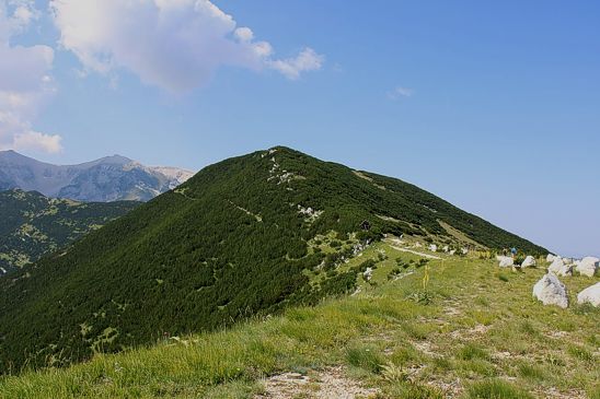 L’Abruzzo, terra di montagne selvagge e panorami sconfinati, offre itinerari escursionistici di straordinaria bellezza. Tra questi, il percorso che dal Blockhaus conduce alla Tavola dei Briganti è uno dei più suggestivi. Partendo dai prati della Majelletta e superato il colle del Blockhaus, il sentiero si snoda attraverso un ambiente di alta quota caratterizzato da vaste distese erbose e fitte mughete. Lungo il cammino, lo sguardo si apre su valloni spettacolari come quelli di Selvaromana, delle Tre Grotte e dell’Orfento, dove la natura conserva ancora il suo aspetto più incontaminato e selvaggio. La cima del Blockhaus, con i suoi 2143 metri di altitudine, domina il versante settentrionale della Maiella ed è facilmente raggiungibile grazie a una strada asfaltata che sale da Passolanciano-Maielletta. Lungo il percorso si incontrano punti di interesse come Cima Mammarosa e il rifugio Bruno Pomilio, mete molto apprezzate dagli escursionisti. Il paesaggio che circonda la vetta è un susseguirsi di rocce affioranti, pascoli d’alta quota e boschi di pino mugo, una vegetazione resistente che testimonia le condizioni estreme tipiche di queste altitudini. Proseguendo lungo il sentiero, si giunge ai piedi del Monte Focalone, dove affiorano lastre di roccia incise nel tempo da pastori e briganti. Tra queste incisioni, una delle più celebri rimprovera a Vittorio Emanuele II di aver trasformato il "regno dei fiori" nel "regno della miseria", lasciando traccia di un’epoca in cui il brigantaggio era espressione di protesta sociale. La Tavola dei Briganti è una vera e propria pagina di storia scolpita sulla pietra, un luogo che racconta il passato e le vicende di chi un tempo percorreva queste montagne alla ricerca di libertà e riscatto. Il Blockhaus e i suoi sentieri rappresentano non solo un paradiso per gli escursionisti, ma anche un patrimonio naturale e storico di inestimabile valore. Il modellamento geologico della montagna, frutto di millenni di trasformazioni, ha creato un ambiente unico, dove la roccia calcarea, le valli glaciali e la vegetazione d’alta quota si fondono in un paesaggio maestoso. Camminare tra questi sentieri significa immergersi in una dimensione fuori dal tempo, dove la natura e la storia si intrecciano in un equilibrio perfetto, offrendo un’esperienza indimenticabile agli amanti della montagna e della bellezza autentica dell’Abruzzo.
