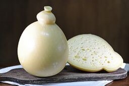 Il caciocavallo d'Abruzzo è uno dei formaggi più rappresentativi della tradizione casearia regionale, nato nei pascoli montani dove il latte fresco di mucca viene lavorato con maestria artigianale. Caratterizzato dalla tipica forma a goccia, questo formaggio a pasta filata si distingue per la sua consistenza elastica e il sapore ricco, che varia dal dolce e delicato nelle versioni giovani al più intenso e piccante con la stagionatura. La produzione del caciocavallo in Abruzzo è legata a metodi tramandati da generazioni, che valorizzano le materie prime locali e il microclima delle zone interne. Il caciocavallo d’Abruzzo viene stagionato appeso, spesso in grotte naturali o cantine fresche, dove sviluppa profumi e aromi che raccontano il legame profondo con il territorio. È un formaggio versatile, apprezzato sia da solo sia come ingrediente in numerosi piatti tipici, capace di esaltare la cucina tradizionale abruzzese. Oggi rappresenta non solo un prodotto gastronomico di qualità, ma anche un simbolo di identità e cultura rurale, portando sulle tavole il gusto autentico e la storia di una terra ricca di tradizioni.