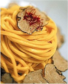 Come fare la Chitarra allo zafferano dell' Aquila con tartufo nero d'Abruzzo. Disponete la farina con una presa di sale a fontana sulla spianatoia e sgusciate al centro le uova. Lavorate energicamente la pasta fino a ottenere un composto ben amalgamato, quindi avvolgete l’impasto nella pellicola trasparente e ponetelo a riposare in frigorifero per mezz’ora. Stendete l’impasto con il matterello fino a ottenere una sfoglia di 2 mm di spessore; ricavate diversi rettangoli di dimensione inferiore alla chitarra, appoggiateli sui fili e fate scorrere sopra il matterello fino a tagliare la pasta (in alternativa stendete la pasta con la macchinetta e passatela alla taglierina). Sistemate la pasta su un vassoio leggermente infarinato, copritela con un canovaccio e fatela riposare. Cuocete la pasta in abbondante acqua salata, scolatela al dente e fatela saltare in una padella insieme con una noce di burro, lo zafferano in polvere e il brodo vegetale. Amalgamate il tutto e servite nei piatti individuali ben caldi con scaglie di tartufo nero e stimmi di zafferano, aggiungendo un filo di olio extravergine di oliva.