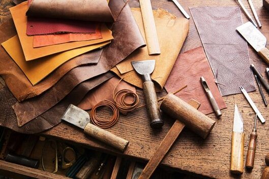 L'artigianato del cuoio e della pelletteria in Abruzzo è una tradizione che rispecchia la maestria degli artigiani locali, i quali lavorano il cuoio con passione e dedizione, creando prodotti unici e durevoli. La lavorazione del cuoio inizia con la selezione delle migliori pelli, che vengono trattate e preparate per ottenere un materiale resistente e di alta qualità. Ogni fase del processo, dalla concia alla cucitura, è eseguita manualmente con grande attenzione ai dettagli, in modo da ottenere articoli che non solo sono esteticamente piacevoli, ma che hanno anche una lunga durata nel tempo. Questa tradizione artigianale, tramandata di generazione in generazione, si caratterizza per un'accuratezza che trasforma ogni pezzo in un'opera d'arte funzionale. Le borse e le cinture in cuoio abruzzese sono tra i prodotti più apprezzati, sia per la loro robustezza che per il design elegante e raffinato. Gli artigiani, utilizzando tecniche tradizionali, confezionano ogni articolo con una cura particolare per le finiture, facendo attenzione alle cuciture, che sono realizzate con fili resistenti e una precisione quasi maniacale. Ogni borsa e cintura racconta una storia di abilità artigianale, con dettagli che esprimono l'autenticità e la cultura abruzzese. Spesso, questi prodotti vengono arricchiti da accessori come fibbie in metallo, incisioni o decorazioni, che rendono ogni pezzo davvero esclusivo. Anche le calzature artigianali abruzzesi sono il frutto di una lavorazione accurata e sapiente. Ogni scarpa o stivale è realizzato a mano, con l’obiettivo di garantire il massimo comfort e una perfetta adattabilità al piede. Gli artigiani abruzzesi scelgono pelli di qualità e le lavorano con tecniche che rispettano la tradizione, ma che al tempo stesso si adattano alle esigenze moderne. L'attenzione ai dettagli è fondamentale in ogni fase della produzione, dalla modellatura della tomaia alla realizzazione della suola, passando per la rifinitura finale, che conferisce al prodotto un aspetto elegante e sofisticato. Il lavoro artigianale del cuoio in Abruzzo, pur rimanendo fedele alle tecniche tradizionali, è oggi in grado di coniugare l'antica arte della pelletteria con le nuove tendenze del design. Gli artigiani abruzzesi, infatti, pur continuando a produrre articoli dal fascino intramontabile, sono anche in grado di adattarsi ai cambiamenti del mercato, creando collezioni che soddisfano i gusti più moderni. Ogni pezzo, che si tratti di una borsa, una cintura o una scarpa, è il risultato di una tradizione che sa rinnovarsi, mantenendo intatto il valore della lavorazione artigianale e il legame con la cultura e le radici del territorio.