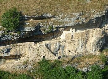 L’Eremo di San Bartolomeo di Legio, situato nel suggestivo territorio di Roccamorice in provincia di Pescara, rappresenta uno dei più affascinanti esempi di architettura religiosa immersa nella natura incontaminata dell’Abruzzo. Incastonato tra le ripide pareti rocciose del Parco Nazionale della Majella, l’eremo si sviluppa in una serie di ambienti scavati nella roccia, che testimoniano la vita ascetica e il profondo spirito di penitenza dei monaci che vi si ritiravano. La sua posizione isolata e panoramica, sospesa tra cielo e terra, offre un’atmosfera di silenzio e raccoglimento che ha da sempre attratto pellegrini e visitatori in cerca di spiritualità e contatto con la natura selvaggia. Nel corso dei secoli, l’Eremo di San Bartolomeo di Legio ha mantenuto intatto il suo fascino antico, conservando elementi architettonici e decorativi che raccontano la storia del monachesimo abruzzese e la devozione per il santo patrono. La presenza di affreschi, altari rupestri e piccoli ambienti di preghiera rende questo luogo un importante punto di riferimento culturale e religioso, capace di unire la dimensione mistica a quella storica. Ancora oggi, l’eremo è meta di pellegrinaggi e cammini spirituali, rappresentando un legame prezioso tra la tradizione religiosa dell’Abruzzo e il suo paesaggio naturale unico.