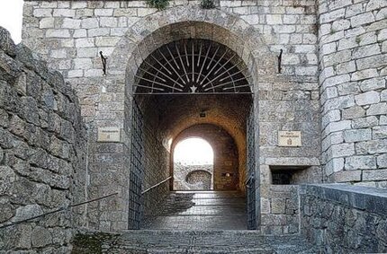 La Storia della Roccaforte della Fortezza di Rocca di Civitella. La Roccaforte di Rocca di Civitella, situata nel comune di Civitella del Tronto in provincia di Teramo, è una delle più grandi e maestose fortificazioni dell'Abruzzo. La sua costruzione iniziò nel XIII secolo, quando fu eretta dai conti di Teramo come punto strategico di difesa. La rocca venne costruita su un'altura dominante la valle del Tronto, offrendo una vista panoramica che permetteva di monitorare e proteggere le vie di comunicazione tra l'Abruzzo e le Marche. La sua posizione privilegiata e le imponenti fortificazioni la rendevano ideale per respingere eventuali attacchi nemici. Nel corso dei secoli, la Roccaforte di Civitella passò sotto il controllo di diverse famiglie nobiliari e, nel XVI secolo, entrò a far parte dei domini degli spagnoli. Durante il periodo del dominio spagnolo, la rocca subì ampliamenti significativi, che la trasformarono in una delle fortificazioni più robuste e avanzate della regione. La sua struttura fu rafforzata con l’aggiunta di bastioni e torri angolari, e venne progettato un sistema di fortificazioni all’avanguardia per l'epoca. La roccaforte divenne così uno degli avamposti principali della difesa della zona, particolarmente durante le guerre contro le truppe francesi e i conflitti con altri stati europei. Con il declino del sistema feudale e l'evoluzione delle tecniche militari nel XVII secolo, la funzione difensiva della Roccaforte di Civitella cominciò a venire meno. Dopo il periodo di massimo splendore, la fortezza subì il lento degrado dovuto a guerre, terremoti e abbandono. Nonostante i danni subiti durante i secoli, la roccaforte rimase un simbolo del potere e della resistenza della comunità locale. Alla fine del XVIII secolo, il castello cessò di avere un ruolo militare attivo, e la sua importanza strategica diminuì considerevolmente, anche a causa della centralizzazione del potere nelle mani dei grandi centri urbani. Oggi, la Roccaforte di Rocca di Civitella è una delle principali attrazioni turistiche dell'Abruzzo, grazie alla sua storia affascinante e al suo stato di conservazione. Dopo importanti lavori di restauro, la rocca è stata riaperta al pubblico, permettendo di esplorare le sue antiche mura, le torri, e i sotterranei che raccontano secoli di storia militare e sociale. La sua architettura imponente e la posizione panoramica sulla vallata del Tronto offrono una vista mozzafiato, mentre eventi culturali e mostre continuano a celebrarne il ruolo storico nella regione. La Roccaforte di Civitella rappresenta un legame profondo con il passato dell'Abruzzo, una testimonianza della sua resistenza e della sua cultura.