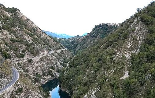 Le Gole del Sagittario, situate nel Comune di Anversa degli Abruzzi (AQ), rappresentano uno dei paesaggi più suggestivi dell'Appennino centrale. Scavate nel corso di milioni di anni dall'azione erosiva del Fiume Sagittario, queste spettacolari formazioni calcaree offrono un ambiente unico dove la natura si manifesta nella sua massima espressione. L'area, riconosciuta come Riserva Naturale Regionale e Zona Speciale di Conservazione, si estende su circa 450 ettari, comprendendo un mosaico di ambienti che vanno dal fondovalle alle praterie d'alta quota. L'ecosistema delle gole è caratterizzato da una straordinaria biodiversità. La vegetazione spazia dai boschi mesofili alle faggete, passando per i prati aridi e le pareti rocciose, dove crescono specie rare ed endemiche. Tra queste, il fiordaliso del Sagittario, pianta simbolo della riserva, e l'efedra dei Nebrodi, una rarità botanica di grande valore scientifico. Le profonde gole e le falesie calcaree ospitano inoltre una ricca varietà di licheni e muschi, testimoni di un ambiente incontaminato. La fauna del territorio è altrettanto ricca e variegata. Qui trovano rifugio i grandi mammiferi appenninici come l'orso bruno marsicano, il lupo, il camoscio d'Abruzzo, oltre a caprioli, cervi e cinghiali. Piccoli predatori come la volpe, la martora e il gatto selvatico popolano il sottobosco, mentre i cieli delle gole sono sorvolati dall'aquila reale, dal falco pellegrino e dal gracchio corallino. L'avifauna annovera numerose specie di uccelli di montagna, tra cui la rondine montana e il picchio muraiolo. Oltre alla ricchezza naturale, il paesaggio delle Gole del Sagittario offre scorci di rara bellezza. Il fondovalle, posto a circa 700 metri di quota, contrasta con le vette che raggiungono i 1.500 metri sul livello del mare, creando un ambiente suggestivo e dinamico. Le pareti rocciose, modellate dall'azione delle acque, raccontano una storia geologica che risale a oltre 200 milioni di anni fa, testimoniando l'evoluzione del territorio attraverso ere di cambiamenti climatici e geologici. L'oasi naturalistica delle Gole del Sagittario non è solo un paradiso per gli amanti della natura, ma anche un luogo di scoperta e apprendimento. Durante tutto l'anno, vengono organizzate attività come escursioni guidate, corsi di riconoscimento della flora e della fauna, laboratori di educazione ambientale e manifestazioni culturali. Questo impegno nella conservazione e nella valorizzazione dell'area permette di tramandare alle future generazioni il patrimonio naturale e culturale di uno dei luoghi più affascinanti dell'Abruzzo.