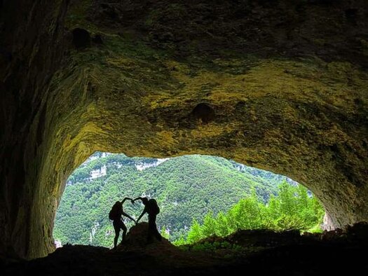 Le Grotte naturali in Abruzzo: Grotta Cavaliera. Le Grotte naturali in Abruzzo. La Grotta Cavaliera è un'affascinante cavità situata nel cuore della Maiella orientale, nella Valle dell'Avello. Questo luogo ha rappresentato per secoli un rifugio per i pastori che praticavano la transumanza, trasferendo le greggi verso i pascoli d'altura con l'arrivo della primavera e riportandole a valle in autunno. La valle è attraversata dal fiume Avello, che nasce sul Monte Cavallo a 2.178 metri sul livello del mare e scorre per 19 chilometri, dividendo il suo corso tra la Valle delle Tre Grotte e la Valle di Selvaromana. L'ambiente suggestivo e incontaminato della grotta testimonia l'importanza di queste antiche tradizioni pastorali, ancora vive nel ricordo delle comunità locali. L'ampia cavità della Grotta Cavaliera si articola in tre stanze non comunicanti, ciascuna con caratteristiche peculiari. La più grande è protetta da un muro a secco e si erge sopra la roccia, offrendo un riparo sicuro nei secoli passati. Una piccola porta in legno permette l’accesso a un ambiente più raccolto e nascosto, noto come "Grotta Piccola della Cavaliera". Secondo alcune fonti storiche, il nome originario della grotta sarebbe "Grotta di Sant'Anna", poiché al suo interno venivano celebrate messe in onore della santa, spesso officiate da frati eremiti che trovavano in questi luoghi solitari un perfetto contesto per la meditazione e la preghiera. Per raggiungere la grotta, è necessario percorrere un suggestivo itinerario che parte dalla località Balzolo di Pennapiedimonte e attraversa il Rifugio Pischioli, lungo la Valle dell’Avello. Il cammino, immerso nella natura selvaggia della Maiella, regala scorci panoramici mozzafiato che si estendono fino alla costa adriatica. Lungo il percorso si possono osservare formazioni rocciose particolari e una vegetazione rigogliosa, tipica dell’ecosistema montano. Questo luogo è molto apprezzato dagli escursionisti e dagli amanti della natura, che qui possono ammirare la straordinaria bellezza di un territorio ancora incontaminato. La Grotta Cavaliera rappresenta non solo un'importante testimonianza storica della vita pastorale sulla Maiella, ma anche un luogo di grande fascino naturalistico. La sua posizione strategica e la sua conformazione unica la rendono una meta ideale per chi desidera immergersi nella storia e nelle tradizioni abruzzesi. Il silenzio e la maestosità della grotta trasmettono un senso di pace e connessione con la natura, rendendo ogni visita un'esperienza indimenticabile. Le storie di pastori, eremiti e viaggiatori che hanno trovato riparo tra queste pareti rocciose continuano a riecheggiare, mantenendo viva la memoria di un passato che si fonde armoniosamente con il presente.