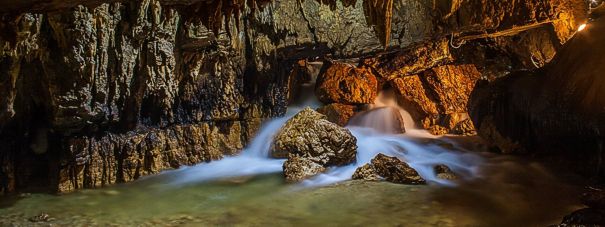 Le Grotte naturali in Abruzzo: Grotte di Stiffe - San Demetrio Ne' Vestini. Le Grotte di Stiffe sono una meraviglia naturale situata nel comune di San Demetrio Ne' Vestini, nella provincia de L'Aquila. L'ingresso della grotta si trova nella parete rocciosa che sovrasta il paese, un punto suggestivo da cui inizia il percorso sotterraneo. L'itinerario si sviluppa per circa 700 metri, lungo i quali i visitatori si addentrano nel cuore della montagna, seguendo il corso di un fiume sotterraneo che proviene dagli inghiottitoi dell’altopiano carsico di Rocca di Mezzo. Durante il cammino, l’acqua crea laghetti, rapide e cascate, che arricchiscono il paesaggio sotterraneo con una bellezza mutevole, che cambia in base alla stagione e alla portata del fiume. All'interno della grotta, le spettacolari formazioni di stalattiti e stalagmiti si alternano a ambienti ampi e affascinanti, che colpiscono per le loro dimensioni e per gli effetti visivi creati dalla rifrazione della luce sulle concrezioni calcaree. La potenza dell’acqua che scorre attraverso il fiume sotterraneo ha modellato queste cavità in modo unico, creando spettacolari cascate e rapide alte fino a venti metri. Il suono dell’acqua che scivola sulle rocce aggiunge un ulteriore elemento suggestivo all'esperienza, rendendo la visita un'occasione per entrare in contatto con la natura in una delle sue forme più pure e incontaminate. Oltre alle bellezze naturali all’interno della grotta, i visitatori possono ammirare anche le cascate che si formano all'esterno, quando l’acqua defluisce dalla cavità sotterranea. Queste cascate sono un altro elemento affascinante che arricchisce il paesaggio circostante, offrendo uno spettacolo che si integra perfettamente con il contesto naturale delle montagne abruzzesi. Il flusso d’acqua, che varia a seconda delle stagioni, conferisce all'ambiente un’atmosfera dinamica, con il paesaggio che si trasforma continuamente in base alla forza della natura. Nei pressi delle Grotte di Stiffe, i visitatori possono esplorare anche Aquilandia, un museo tematico che approfondisce il patrimonio naturalistico e architettonico dell’Abruzzo. Con una vasta area espositiva, il museo ospita una serie di riproduzioni in scala di monumenti, parchi e siti storici della regione, offrendo un ulteriore strumento di apprendimento per chi desidera conoscere meglio il territorio. Aquilandia è attrezzato con audioguide e un percorso per non vedenti, e rappresenta una risorsa didattica che arricchisce ulteriormente l’esperienza culturale e turistica legata alle Grotte di Stiffe.