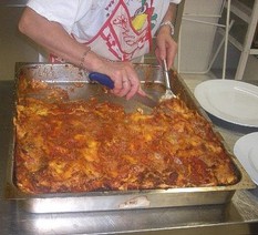 Preparazione del timballo all'aquilana. Ammassare la farina con le uova, un pizzico di sale e olio. Ottenuto un impasto abbastanza duro, tirare le sfoglie, delle quali una deve essere di diversi centimetri più grande del testo, bordi compresi. Preparare delle minute polpettine con la carne macinata, farle rosolare insieme all'aglio ed alle cipolle tritate, e quindi aggiungere il pomodoro. Far cuocere molto lentamente. Lessare leggermente le sfoglie in acqua salata. Ungere bene il testo per il timballo e cospargerlo di pane grattugiato. Sistemare sul fondo la sfoglia più grande, che fuoriesca dal testo. mettere del pomodoro con le polpettine, della mozzarella affettata, una manciata di parmigiano grattugiato e qualche fettina di uovo sodo. Continuare con la sfoglia ed il ripieno. Chiudere con la sfoglia. Ripiegare la sfoglia che fuoriesce dal bordo e far aderire a quella di chiusura. Infornare per c.a. mezzora a 180°.