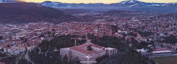 L'Aquila (714 m. slm.), capoluogo della regione Abruzzo, è una straordinaria città ricca di arte e cultura situata nel comprensorio del Parco Nazionale del Gran Sasso-Monti della Laga, alla sinistra del fiume Aterno. E' circondata da una  suggestiva catena di monti tra i quali spicca, a nord-est, l'imponente massiccio del Gran Sasso d'Italia (2.912 m.). Il territorio comunale (circa 68.500 abitanti), in massima parte montuoso ad eccezione della vallata del fiume Aterno (considerato il fiume più freddo d'Italia), ha una variazione altimetrica che va da un minimo di 575 m. ad un massimo di 2.635 m. slm. Nel territorio aquilano è compresa parte dell'altopiano di Campo Imperatore, l'altopiano carsico più vasto d'Europa, che dispone di piste da sci e campi di neve tra i più estesi ed apprezzati della regione. La città, sorta intorno alla metà del XIII secolo, visse numerose ed alterne vicende storiche fino al 1860, anno in cui si unì al nascente Regno d'Italia. Nel 1703 fu parzialmente distrutta da un violento terremoto che provocò oltre 6.000 vittime. L'Aquila, città dalle 99 chiese a ricordo dei 99 castelli che, secondo la leggenda, contribuirono alla sua fondazione, è ricca di monumenti di enorme valore storico-artistico. Il più celebre è indubbiamente la basilica di S. Maria di Collemaggio, simbolo della città ed una delle pochissime chiese al mondo ad avere, al pari della basilica di S. Pietro in Roma, una Porta Santa. Le origini del tempio, eretto tra il 1283 e il 1288,  sono legate all'umile eremita Pietro da Morrone che pochi anni dopo, nel 1294, fu incoronato Papa nella stessa chiesa aquilana con il nome di Celestino V. Le sue reliquie sono custodite all'interno della basilica, in un mausoleo del 1517 che rappresenta un autentico capolavoro rinascimentale. Ogni anno, il 29 agosto, nel capoluogo si celebra la Perdonanza Celestiniana, con apertura della Porta Santa e indulgenza  plenaria concessa dal papa eremita. Altri monumenti tra i più rappresentativi del capoluogo abruzzese sono il poderoso e ben conservato Forte Cinquecentesco, una delle principali fortezze presenti in Italia, chiamato anche "Forte Spagnolo" perchè fu costruito, nel 1534, per volere dei dispotici governatori spagnoli; la maestosa basilica di S. Bernardino (XV sec.), la chiesa più grande della regione; la famosissima ed antica Fontana delle 99 cannelle, edificata nel 1272 presso il fiume Aterno; la chiesa di S. Giusta di Bazzano (XIV sec); la cattedrale, di origine duecentesca, di S. Massimo  e S. Giorgio; l'antica chiesa di S. Maria di Paganica; la chiesa di S. Agostino (XVIII sec.); etc. Nel lungo elenco devono essere altresì comprese le decine di splendidi palazzi gentilizi, di epoche comprese tra il XV ed il XX secolo, spesso arricchiti da bellissimi cortili con scenografici porticati ad archi sorretti da colonne e monumentali scalinate. Anche alcune tra le numerose stupende frazioni sparse nei dintorni della città conservano monumenti o reperti di notevole interesse storico-artistico. Sono sicuramente da citare la frazione di S. Vittorino, dove si trovano il Teatro e l'Anfiteatro Romano dell'antica Amiternum, la chiesa di S. Michele (XII sec.) e la catacomba di S. Vittorino; la frazione di Paganica, con il suggestivo Santuario della Madonna d'Appari (XIII sec.), incastonato nella roccia e con la volta tappezzata da meravigliosi affreschi; la frazione di Civita da Bagno dove sono visibili i resti della cattedrale di S. Massimo a Forcona (VII sec.); il pittoresco e frequentatissimo borgo fortificato di Assergi, che custodisce la bellissima chiesa di S. Maria Assunta (1150); etc. In conclusione: sia L'Aquila, città d'arte alla quale sono stati attribuiti i prestigiosi appellativi di "Firenze d'Abruzzo" e "Salisburgo d'Italia", che le piccole frazioni vicine sono località che meritano di essere assolutamente visitate!