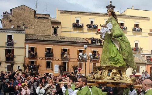 La Madonna che scappa a Sulmona rappresenta uno dei momenti più intensi e suggestivi della Pasqua abruzzese, un rito che unisce fede, teatro popolare e partecipazione collettiva in un’unica, coinvolgente celebrazione. La tradizione si svolge nella piazza principale della città, dove l’attesa cresce sin dalle prime ore del mattino tra fedeli, visitatori e curiosi. Il cuore del rito è il simbolico incontro tra la Madonna e il Cristo risorto: inizialmente la statua della Vergine, vestita a lutto, viene portata in processione con passo lento e solenne, accompagnata da altre statue e da confraternite locali. Il momento culminante avviene quando, attraverso un gesto improvviso e carico di significato, la Madonna “riconosce” il Figlio risorto e, liberandosi del mantello nero del dolore, corre verso di lui, in una rappresentazione che esprime il passaggio dalla sofferenza alla gioia della Resurrezione. Questo evento, profondamente radicato nella cultura di Sulmona e dell’intero Abruzzo, non è soltanto una manifestazione religiosa, ma anche un’espressione identitaria che coinvolge l’intera comunità. L’emozione si percepisce nella partecipazione corale dei cittadini, nei riti preparatori tramandati di generazione in generazione e nel silenzio carico di attesa che precede il momento clou. La Madonna che scappa a Sulmona diventa così un’esperienza condivisa, capace di unire spiritualità e tradizione popolare, rafforzando il senso di appartenenza e mantenendo vivo un patrimonio culturale che continua a rinnovarsi ogni anno. Tra fede e spettacolarità, il rito conserva intatta la sua forza evocativa, trasformando la Pasqua in Abruzzo in un’occasione unica di partecipazione emotiva e memoria collettiva.