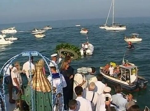 La festa della Madonna del Portosalvo è una delle manifestazioni più sentite e ricche di tradizione nella provincia di Teramo, un evento che affonda le sue radici nella devozione popolare e nella vita marittima della comunità di Giulianova. Ogni anno, nei giorni intorno al 15 agosto, la cittadina rivierasca si anima di colori, suoni e emozioni, in una celebrazione che unisce la religiosità alla festa popolare. La figura della Madonna del Portosalvo, protettrice dei pescatori, è il cuore pulsante di questa festa che, con il passare degli anni, è diventata un vero e proprio rito collettivo che coinvolge tutta la comunità. Il giorno della festa, il porto di Giulianova diventa il palcoscenico di una suggestiva processione in mare. Le imbarcazioni dei pescatori, adornate con bandierine colorate e fiori, partono in una lunga fila, guidate dalla barca che porta la statua della Madonna. Questo momento è carico di significato, perché rappresenta il legame profondo tra i pescatori e la loro protettrice. La fede nella Madonna del Portosalvo è radicata nella tradizione secolare di coloro che lavorano in mare, un luogo tanto affascinante quanto pericoloso, dove la protezione divina è vissuta come una necessità quotidiana. L’atmosfera che si respira durante la festa è unica. Non si tratta solo di una celebrazione religiosa, ma di un’occasione di aggregazione sociale e di espressione di identità culturale. I pescatori e le loro famiglie, ma anche i visitatori, si ritrovano per condividere momenti di festa che vanno oltre il rituale. Il porto diventa un luogo di incontro, dove le tradizioni culinarie locali si mescolano ai canti folkloristici e alle danze popolari. Le strade di Giulianova si riempiono di bancarelle e di musiche che animano l'intera cittadina, creando un'atmosfera di allegria che coinvolge tutti, giovani e anziani. Un aspetto fondamentale della festa è il coinvolgimento diretto dei marinai, che curano ogni dettaglio delle loro imbarcazioni con dedizione e passione. Ogni barca decorata non è solo un mezzo di trasporto, ma una vera e propria offerta alla Madonna, un atto di devozione che va oltre il semplice ornamento. Non c’è competizione, ma un sincero impegno a onorare la figura della Madonna del Portosalvo, simbolo di protezione e speranza per i pescatori. La cura con cui ogni barca viene preparata testimonia la fede e il rispetto che la comunità ha verso la propria tradizione e la propria patrona. La festa si conclude con un grande spettacolo di fuochi d'artificio, che illumina il cielo di Giulianova in una celebrazione di gioia e gratitudine. Mentre le barche tornano al porto, i fuochi esplodono in un tripudio di colori, seguiti dal suono della musica che accompagna il ritorno della Madonna sulla terraferma. Questo finale festoso simboleggia il ritorno a casa dei pescatori, ma anche la protezione che la Madonna continua a offrire loro. La festa della Madonna del Portosalvo è, quindi, un momento di unione profonda, dove la spiritualità e il folklore popolare si mescolano in un’unica grande celebrazione di fede, cultura e comunità.