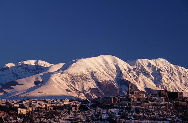 Il mare e la montagna in Abruzzo: Il monte Majella. La Majella, uno dei massicci più imponenti degli Appennini, si erge maestosa nel cuore dell’Abruzzo, con la sua vetta più alta, il Monte Amaro, che raggiunge i 2.793 metri. Questo straordinario massiccio, che divide le province di Chieti, L'Aquila e Pescara, è un autentico scrigno di biodiversità e bellezza naturale. Il Parco Nazionale della Maiella, che lo ospita, è una delle aree protette più significative della regione, un luogo dove la montagna incontra la storia e le tradizioni locali. Le valli, le gole e le cime che compongono il massiccio sono un richiamo irresistibile per gli amanti della natura e dell’avventura, offrendo un ampio ventaglio di opportunità per trekking, escursioni e arrampicate. La Majella si distingue per la sua morfologia variegata, che alterna zone strette e allungate a ovest con valli più larghe a est, creando paesaggi unici. L'area occidentale è delimitata dalla Conca Peligna, mentre quella orientale si estende fino alle colline che separano il massiccio dalla costa adriatica. La forma della montagna, composta da calcare compatto, le conferisce un aspetto severo e misterioso, tipico delle montagne più alte. I panorami che si possono godere dalla sua cima sono spettacolari e si estendono per centinaia di chilometri, tanto che la Majella è visibile da luoghi lontani come il Gargano, il Monte Amiata e persino dalle alture della Dalmazia. Inoltre, la Majella è famosa per i suoi numerosi gruppi montuosi e altipiani, come il Monte Morrone, il Monte Porrara e i Monti Pizzi, che contribuiscono a delineare l’imponenza del paesaggio. Le valli che separano questi gruppi dal massiccio della Maiella, come quelle dell'Orta e dell'Aventino, offrono un’ulteriore dimensione di bellezza naturale, con boschi, prati e corsi d’acqua che creano un ecosistema ricco e variegato. Queste zone sono perfette per gli appassionati di escursionismo, ma anche per chi desidera immergersi in un paesaggio più intimo e appartato, lontano dai luoghi più frequentati. Nonostante la sua maestosità, la Majella è anche un luogo che racconta la storia e la cultura del popolo abruzzese. Le sue montagne sono da sempre state testimoni di leggende e tradizioni, che affondano le radici nella storia millenaria della regione. Nei borghi che circondano il massiccio, come quelli di Sulmona e Caramanico Terme, si possono ancora respirare l’atmosfera di una vita semplice, legata alla montagna e alle sue risorse. La Majella, con i suoi panorami mozzafiato e la sua storia, rimane uno dei luoghi più affascinanti e incontaminati d’Abruzzo, capace di regalare emozioni uniche a chiunque abbia il privilegio di esplorarla.