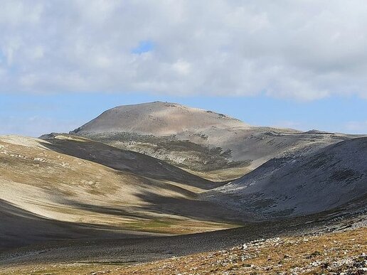 La Majella è uno dei massicci montuosi più imponenti e affascinanti dell’Appennino centrale, situata interamente in Abruzzo. Conosciuta anche come la “montagna madre” per il suo legame profondo con la cultura e la spiritualità del territorio, si presenta come una grande cupola calcarea, aspra e selvaggia, attraversata da valloni profondi, altipiani e conche modellate dai ghiacciai. La sua straordinaria varietà paesaggistica ospita una biodiversità unica, con ambienti che vanno dai boschi di faggio e roverella alle praterie d’alta quota, dove vivono numerose specie endemiche e protette. È una montagna che conserva un forte senso di autenticità, dove natura, storia e spiritualità si intrecciano in modo indissolubile. La vetta più alta del massiccio è il Monte Amaro, che con i suoi 2.793 metri è la seconda cima dell’Appennino dopo il Gran Sasso. La salita al Monte Amaro rappresenta una delle esperienze escursionistiche più suggestive in Abruzzo, offrendo panorami spettacolari che spaziano dalle montagne interne fino al mare Adriatico. Questo territorio è anche ricco di testimonianze del passato: lungo i sentieri si incontrano antichi eremi, capanne pastorali in pietra e tracce della presenza umana sin dal Paleolitico. Il Monte Amaro, con la sua imponenza e il suo silenzio, incarna il cuore selvaggio della Majella e l’anima profonda dell’Abruzzo.