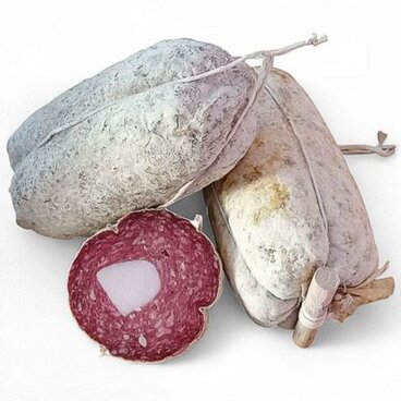 Le mortadelline di Campotosto (Aq). Il patrimonio dei Sapori Autentici dell’Abruzzo si arricchisce di una prelibatezza unica, le mortadelline di Campotosto, conosciute anche con il nome di "coglioni di mulo". Questo salume tradizionale è prodotto in piccole quantità nel comune di Campotosto, in provincia dell’Aquila, e nelle zone circostanti. La sua rarità e l'autenticità lo rendono un vero e proprio tesoro gastronomico, apprezzato da pochi intenditori che ne riconoscono il valore e la qualità artigianale. La storia della mortadella di Campotosto affonda le radici in tradizioni che risalgono a oltre 500 anni fa. Nel corso dei secoli, la città di Amatrice ha cercato di rivendicare la paternità di questo salume, complice il dominio che esercitò su Campotosto e sui comuni vicini nel Medioevo. Oggi, solo pochi artigiani della zona continuano a produrre questo salume, mantenendo viva una tradizione che rischiava di scomparire, e rendendolo un prodotto raro e prezioso. La preparazione della mortadella di Campotosto è un processo che rispetta rigorosamente le tradizioni locali. Composta esclusivamente da carne di suino proveniente dai maiali allevati nei Monti della Laga, la mortadella si distingue per la sua forma ovoidale e per la finezza della grana dell’impasto. All'interno, lungo tutta la lunghezza del salume, è presente una barretta di lardo che ne accentua il sapore e la morbidezza. Quando viene affettata, il contrasto tra il rosa della carne e il bianco del lardo la rende facilmente riconoscibile. Il procedimento di lavorazione segue una tradizione che richiede tempo e attenzione. Dopo che la carne è stata macinata finemente e condita con sale, pepe e vino bianco, l’impasto riposa per un giorno intero, durante il quale viene mescolato con un infuso di chiodi di garofano e cannella. Successivamente, l’impasto viene insaccato manualmente in un budello che viene cucito con cura, e il prodotto viene appeso a stagionare. Solo dopo almeno tre mesi di maturazione, il salume acquisisce il suo sapore inconfondibile, pronto per essere gustato in tutta la sua autenticità.
