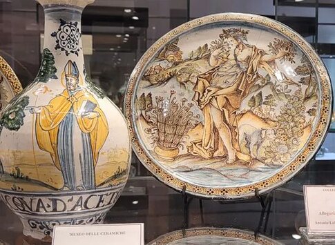 Il Museo delle Ceramiche di Castelli, situato nell’omonimo borgo abruzzese, è un luogo che celebra la secolare tradizione della ceramica artistica locale, riconosciuta come una delle più importanti espressioni culturali della regione. Castelli, famoso per la sua scuola di ceramisti, ha dato vita a manufatti che nel corso dei secoli sono diventati simbolo dell’artigianato abruzzese e dell’arte popolare. Il museo, ospitato in un suggestivo edificio nel cuore del paese, raccoglie una ricca collezione di opere che raccontano la storia e l’evoluzione della ceramica castellana. Il percorso espositivo del museo si articola in diverse sezioni tematiche, che illustrano le tecniche, i materiali e gli stili che hanno caratterizzato la produzione ceramica di Castelli. Tra gli oggetti esposti, si possono ammirare piastrelle, vasi, piatti, suppellettili e sculture, realizzati dai maestri ceramisti locali a partire dal XV secolo. I visitatori possono apprezzare le caratteristiche forme e i motivi decorativi tipici di questa tradizione, come l’uso del colore azzurro, il motivo del "ramo d’olivo" e i temi religiosi che decorano spesso le ceramiche. Un aspetto fondamentale del museo è il racconto delle diverse fasi della produzione ceramica, dalla creazione dei modelli in argilla alla cottura nei forni tradizionali, fino alla decorazione a mano. Il museo ospita anche una sezione dedicata alla bottega dei ceramisti, che offre uno spaccato di vita artigianale, mostrando gli strumenti utilizzati dai maestri per modellare e dipingere le ceramiche. Attraverso queste sezioni, i visitatori possono comprendere appieno l’impegno e la dedizione che stanno alla base di ogni pezzo. Il Museo delle Ceramiche di Castelli non è solo un luogo di conservazione, ma anche un centro di promozione culturale. Organizza periodicamente mostre, eventi e laboratori didattici per adulti e bambini, permettendo di avvicinarsi all’arte della ceramica in modo interattivo. Grazie a questa offerta dinamica, il museo diventa una tappa imperdibile per chi vuole scoprire e vivere la tradizione della ceramica di Castelli, simbolo di un artigianato che affonda le radici nella storia e nella cultura dell’Abruzzo.