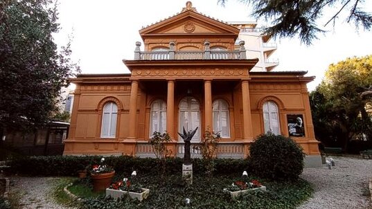 Il Museo Paparella-Treccia Devlet, situato nel cuore di Pescara, ospita una delle collezioni più prestigiose di maioliche antiche di Castelli, una delle tradizioni ceramiche più importanti della regione Abruzzo. La sede del museo è una villa storica di fine Ottocento, Villa Urania, che si trova a pochi passi dalla centrale Piazza della Rinascita. La collezione, frutto di oltre quarant'anni di ricerca del prof. Raffaele Paparella-Treccia, ortopedico di fama, è stata donata nel 1997 dallo stesso Paparella alla fondazione che porta il suo nome e che gestisce il museo in collaborazione con il Comune di Pescara. Le maioliche di Castelli, celebri per la loro qualità e bellezza, sono state una delle eccellenze artigianali d’Abruzzo sin dal XVI secolo. La collezione del museo, composta da 146 esemplari risalenti tra il XVI e il XIX secolo, testimonia l'evoluzione dello stile delle ceramiche castellane, dai primi pezzi caratterizzati da un'estrema essenzialità fino a quelli barocchi e rococò, ricchi di scene storiche, religiose e mitologiche. Tra gli artisti di maggior rilievo rappresentati nel museo vi sono Francesco Grue, Carlo Antonio Grue e Francesco Antonio Grue, così come i Gentili, i Cappelletti e i Fuina, il cui lavoro ha segnato l'apice della produzione ceramica castellana. Oltre alla ceramica, il museo conserva anche una selezione di dipinti significativi, tra cui una Natività quattrocentesca e due interni di cattedrali del Seicento, attribuiti alla scuola di Monsù Desiderio, un gruppo di artisti francesi attivi a Napoli. Queste opere arricchiscono ulteriormente il patrimonio culturale del museo, mettendo in luce la varietà e la profondità dell'arte abruzzese e del periodo barocco, non solo nella ceramica, ma anche nella pittura. La fondazione Paparella-Treccia Devlet è impegnata a mantenere vivo l'interesse per la maiolica castellana e a promuovere la cultura dell'arte in generale. Ogni anno, il museo organizza eventi culturali e attività didattiche che contribuiscono a diffondere la conoscenza della tradizione artistica di Castelli e a sensibilizzare il pubblico sul valore del patrimonio storico-culturale della regione. Grazie a queste iniziative, il Museo Paparella-Treccia Devlet si conferma un punto di riferimento per l'arte e la cultura abruzzese, offrendo ai visitatori non solo un'esperienza estetica, ma anche un'opportunità di apprendimento e riflessione sul passato artistico della regione.