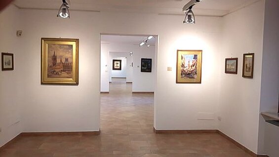 Musei e Raccolte in Abruzzo: Museo d’Arte dello Splendore – Giulianova (Te) Il Museo d'Arte dello Splendore di Giulianova si trova all'interno dell'ala est del convento cappuccino del Santuario della Madonna dello Splendore, in una posizione panoramica che domina la città e il mare Adriatico. Fondato nel 1997 grazie alla volontà di padre Serafino Colangeli, il museo è ospitato in una struttura che si sviluppa su tre piani e che raccoglie al suo interno una ricca e variegata collezione d'arte contemporanea e sacra. La sua nascita è stata accompagnata da un desiderio di valorizzare l'arte in tutte le sue forme, partendo dalle opere degli artisti locali per arrivare alle creazioni di maestri riconosciuti a livello internazionale. Al piano terra, il museo ospita la Collezione Bindi, una delle più importanti raccolte abruzzesi di "scuola di Posillipo", che è stata donata al comune di Giulianova nel 1928 da Vincenzo Bindi. Questa collezione, che include paesaggi e opere legate alla tradizione pittorica napoletana dell'Ottocento, è un omaggio alla bellezza del territorio e alla sua tradizione artistica. La collezione comprende anche opere di Consalvo Carelli, uno dei protagonisti più celebri della scuola, con capolavori come "La Grotta della Sibilla". Il secondo piano del museo è dedicato alla Collezione Permanente, che offre uno spunto sulle tendenze artistiche italiane del XX secolo, con opere di artisti del calibro di Sassu, Corpora, Ceccobelli, Marini e Turcato. La collezione ospita anche spazi per le attività didattiche, rendendo il museo un punto di riferimento per la formazione e la conoscenza dell'arte moderna e contemporanea. Il terzo piano è invece dedicato a mostre temporanee e conferenze, come quella dedicata a Mimmo Paladino, che ha realizzato una serie di otto grandi carte ispirate all'enciclopedia medievale "De Universo". Il Museo d'Arte dello Splendore si distingue per la sua capacità di unire arte contemporanea e arte sacra. Al suo interno si trovano anche sculture di artisti come Francesco Messina, Floriano Bodini e Venanzo Crocetti, oltre a una sezione di acqueforti di Georges Rouault. Queste opere testimoniano l'evoluzione dell'arte religiosa nel Novecento e aggiungono un ulteriore valore alla già ricca offerta del museo. Grazie alla sua missione di valorizzazione culturale, il museo ha ospitato numerose mostre importanti, diventando un punto di riferimento per artisti, studiosi e appassionati d'arte.