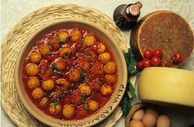 Per preparare le pallotte cace e ove, iniziate ammollando il pane raffermo in acqua per qualche minuto, quindi strizzatelo bene per eliminare l'umidità in eccesso. In una ciotola capiente, unire il pane ammollato con il pecorino grattugiato, le uova, un pizzico di sale e pepe. Impastate il tutto fino a ottenere un composto omogeneo e morbido, che dovrà avere una consistenza tale da poter formare delle piccole polpette. Se necessario, aggiungete altro formaggio o un filo di olio extravergine d’oliva per legare meglio gli ingredienti. Una volta che il composto è pronto, formate delle polpette di circa 3-4 cm di diametro, facendo attenzione a compattarle bene per evitare che si sfaldino durante la cottura. In una padella, scaldate abbondante olio extravergine d'oliva e, quando sarà caldo, friggete le pallotte fino a quando non saranno dorate e croccanti su tutti i lati. La frittura deve essere lenta e uniforme, per permettere alle polpette di cuocere perfettamente all'interno, mantenendo la croccantezza all’esterno. Mentre le pallotte sono in cottura, preparate il sugo di pomodoro. In una casseruola, soffriggete uno spicchio d’aglio in un po’ di olio extravergine d'oliva, fino a quando non diventa dorato. Aggiungete quindi la passata di pomodoro e lasciate cuocere a fuoco medio per circa 20 minuti, regolando di sale e pepe. Il sugo deve diventare denso e saporito, senza però risultare troppo acido, per armonizzarsi perfettamente con il sapore delle polpette. Una volta che le pallotte sono fritte e il sugo è pronto, trasferite le polpette nel sugo di pomodoro e lasciatele cuocere a fuoco lento per circa 10-15 minuti. In questo modo, le polpette assorbiranno i sapori del sugo e diventeranno più morbide, mentre il sugo arricchirà ulteriormente il piatto con un sapore avvolgente. Servite le pallotte cace e ove calde, guarnite con una spolverata di pecorino fresco, se lo desiderate, per esaltare ancora di più il loro sapore autentico.