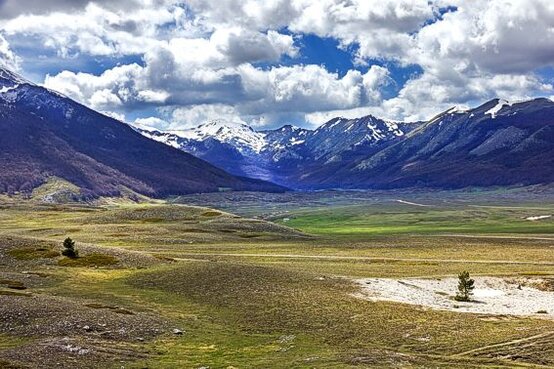 Parchi Naturali, boschi e Trekking: Il Parco Regionale del Sirente-Velino. Il Parco Regionale del Sirente-Velino, facilmente raggiungibile da Roma e altre zone dell’Abruzzo, è una meta ideale per chi cerca una connessione profonda con la natura. In particolare, la sua posizione strategica, a poco più di un’ora dalla capitale, lo rende facilmente accessibile per chi desidera fuggire dal trambusto cittadino e immergersi in un ambiente montano suggestivo. Il Velino, con la sua cima innevata visibile in inverno, è uno dei punti più panoramici e simbolici del parco, che offre ai visitatori paesaggi mozzafiato e una varietà di attività all'aria aperta, dalle passeggiate più tranquille al trekking più impegnativo. Il parco è famoso per la sua varietà di ambienti naturali, che spaziano dalle imponenti pareti rocciose alle zone di ghiaioni, dove crescono specie botaniche rare. Queste terre, ideali per escursionisti e amanti della montagna, offrono la possibilità di esplorare territori selvaggi e poco contaminati. Oltre a essere conosciuto per le piste da sci di Ovindoli e Campo Felice, che attirano visitatori anche durante la stagione invernale, il Parco del Sirente-Velino è apprezzato da chi cerca tranquillità e contatto diretto con la natura attraverso escursioni che conducono a panorami incantevoli. Un aspetto distintivo del Parco del Sirente-Velino è il suo patrimonio storico e culturale. Lungo i sentieri e nei boschi, infatti, è possibile imbattersi in torri medievali, castelli e borghi antichi, che raccontano storie di secoli passati. Le tracce di civiltà più antiche sono visibili anche in alcune aree archeologiche, che testimoniano la lunga storia di questi luoghi, dove l'uomo ha lasciato il segno, integrandosi perfettamente con l’ambiente montano. Le chiese rurali e i conventi, alcuni ancora ben conservati, aggiungono un ulteriore strato di valore storico-culturale, creando una connessione unica tra natura e tradizione. Infine, il Parco Regionale del Sirente-Velino è un esempio perfetto di come la bellezza naturale e il patrimonio storico possano convivere, offrendo a chi lo visita un'esperienza a tutto tondo. Ogni angolo del parco invita alla scoperta, sia per la ricchezza della fauna che per la varietà dei paesaggi, dove boschi, prati e montagne regalano atmosfere suggestive e indimenticabili. È un luogo ideale per chi cerca una meta lontana dai circuiti turistici più battuti, ma al contempo ricca di opportunità per praticare attività all'aria aperta e scoprire le tradizioni abruzzesi.