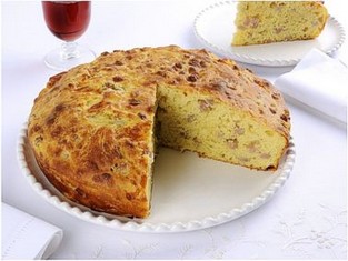 La preparazione della pizza rustica di Santa Chiara di Sulmona. 1) Sciogliete il lievito in una ciotola con un dl di acqua tiepida e lo zucchero. Incorporate 5 cucchiai di farina, lavorate il tutto, formate un panetto morbido e lasciatelo lievitare, coperto, per almeno un'ora. Setacciate la farina rimasta con 2 cucchiaini di sale, fate una fontana, versate al centro l'acqua rimasta, unite il panetto lievitato, le patate schiacciate, il burro e la scamorza a pezzetti, le uova il prosciutto e una macinata di pepe. 2) Lavorate l'impasto almeno 10 minuti, formate una palla, disponetela in una ciotola leggermente unta d'olio, praticate 2 tagli a croce sulla superficie, coprite la ciotola e lasciate lievitare la pasta per 2 ore o finché è raddoppiata di volume. 3) Stendete l'impasto in una teglia di 26 cm. circa unta d'olio e cuocetela in forno a 200° per circa mezz'ora. Servite la pizza tiepida o fredda.