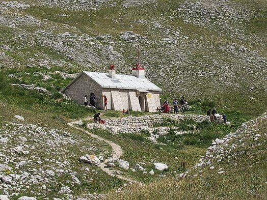 Il Rifugio Giuseppe Garibaldi, situato nel cuore del massiccio del Gran Sasso d'Italia, accoglie escursionisti e alpinisti che desiderano esplorare le vette dell’Appennino abruzzese. Immerso in un ambiente selvaggio e affascinante, il rifugio offre un punto di ristoro e riparo a chi affronta le salite verso il Corno Grande e le altre cime circostanti. La sua posizione, a 2.231 metri di altitudine, lo rende un luogo ideale per ammirare panorami mozzafiato e vivere l’esperienza della montagna in tutta la sua autenticità. La struttura, seppur essenziale, garantisce un'accoglienza calorosa, mettendo a disposizione posti letto e un ambiente rustico e accogliente, perfetto per condividere esperienze di viaggio con altri appassionati di montagna. Nei mesi estivi, il rifugio diventa un punto di riferimento per gli escursionisti che percorrono i sentieri del Gran Sasso, mentre in inverno, con la montagna innevata, rappresenta una meta ambita dagli alpinisti esperti in cerca di sfide più impegnative. Oltre a essere un punto di sosta strategico, il rifugio svolge un ruolo importante nella promozione della cultura della montagna e della tutela dell’ambiente. I gestori e i volontari del Club Alpino Italiano lavorano per mantenere viva la tradizione dell’escursionismo responsabile, sensibilizzando i visitatori sull’importanza del rispetto per la natura e sulle regole di sicurezza in alta quota. Il rifugio è anche un luogo di incontro per chi vuole approfondire la conoscenza della storia dell’alpinismo appenninico, grazie alle testimonianze e ai racconti legati alla sua lunga esistenza. L’accesso al Rifugio Giuseppe Garibaldi avviene attraverso diversi sentieri che partono dalle località circostanti, come Campo Imperatore e Prati di Tivo, con percorsi di varia difficoltà e durata. Ogni cammino conduce a un’esperienza unica, tra creste rocciose, vallate e panorami spettacolari. Raggiungerlo significa immergersi in un’avventura autentica, in cui il fascino della montagna si unisce al senso di libertà e alla soddisfazione della conquista di una meta storica e affascinante.