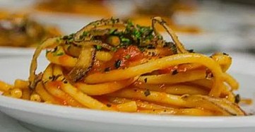 La preparazione dei rintrocili con sugo di agnello, piatto simbolo della tradizione chietina, è un processo che unisce semplicità e maestria artigianale. Si comincia dalla pasta, realizzata con farina di semola di grano duro, acqua e un pizzico di sale. L’impasto viene lavorato a mano con cura fino a ottenere una consistenza liscia ed elastica, che viene poi lasciata riposare per permettere agli ingredienti di amalgamarsi al meglio. Successivamente, l’impasto viene steso con il mattarello in una sfoglia spessa e tagliato a mano in lunghi fili rustici, i rintrocili, che si caratterizzano per la loro forma irregolare e la consistenza ruvida, perfetta per accogliere il sugo. Il sugo di agnello è il cuore della ricetta e richiede tempo e attenzione per esprimere al meglio i suoi sapori. La carne, scelta tra spezzatino o costatine di agnello, viene rosolata in un soffritto di cipolla, carota e sedano, fatto appassire lentamente in olio extravergine d’oliva. Questo passaggio è fondamentale per esaltare il gusto della carne e creare la base del condimento. Una volta rosolata, la carne viene sfumata con un bicchiere di vino bianco, che aggiunge freschezza e profondità al piatto, prima di aggiungere la passata di pomodoro. La cottura del sugo avviene a fuoco lento, per consentire alla carne di diventare tenera e al pomodoro di ispessirsi e amalgamarsi agli aromi. Durante questa fase, si possono aggiungere rosmarino o alloro, che conferiscono al sugo un profumo intenso e un sapore deciso, richiamando i sentori della macchia mediterranea. Il risultato è un condimento denso e saporito, ideale per esaltare la pasta fatta in casa. Quando tutto è pronto, i rintrocili vengono cotti in abbondante acqua salata e scolati al dente, per poi essere mescolati con il sugo di agnello. Il piatto viene servito caldo, completato da un filo di olio extravergine d’oliva a crudo e, se gradito, una spolverata di pecorino abruzzese. Il risultato è un’esplosione di sapori autentici, dove la pasta fresca e il sugo corposo si fondono in un’armonia perfetta, regalando un’esperienza gastronomica che celebra la tradizione della provincia di Chieti.