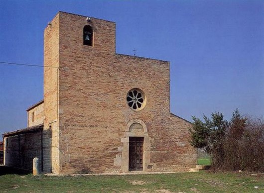 La Chiesa di Santa Maria a Vico a Sant’Omero (Te) Sant’Omero (Te). Chiesa di Santa Maria a Vico. La Chiesa di Santa Maria a Vico, costruita sui resti di un tempio pagano dedicato ad Ercole, la chiesa di santa Maria a Vico sorge vicino al borgo di Sant'Omero. E' considerata come l’unico monumento d’Abruzzo anteriore al Mille giunto a noi quasi completo. Lo schema della pianta è estremamente semplice: un rettangolo allungato diviso in tre navate dove, in corrispondenza di quella centrale, si trova l'abside. I valichi sono scanditi da due file di sei piloni per lato, privi di base e sormontati da capitelli in pietra squadrati. Le cinque finestre, chiuse da transenne in travertino, assicurano all’interno una scarsa illuminazione, compensata però dall’ampio rosone aperto nel prospetto principale. La torre campanaria fu aggiunta nel Trecento, quando anche la facciata subì un'opera di ampio restauro. L'interno della Chiesa era impreziosito da affreschi di notevole fattura come una Madonna in trono col Bambino colta nel gesto affettuoso di stringerlo al volto, un'Annunciazione e una seconda Madonna in trono col Bambino. Purtroppo lo stato di conservazione consente soltanto di evidenziare indiscutibili cadenze giottesche, assorbite molto probabilmente dall’Umbria. Ad altra mano e ad anni prossimi alla metà del Trecento sembrano invece doversi riferire alcuni brani di affresco del sottarco dell’ultimo valico sinistro. Sono superstiti un Cristo Benedicente a mezzo busto entro un clipeo e San Giovanni Evangelista. Nel portale si scorgono dei blocchi di pietra scolpiti “a negativo”, cioè con le figure incassate nella pietra anziché a rilievo. Una di esse è l’agnello con la Croce, il cosiddetto Agnus Dei, ossia l’agnello di Dio. Ci sono poi i simboli degli Evangelisti, con il leone alato di San Marco, il bue alato di San Luca e l’aquila di San Giovanni, oltre a vari motivi geometrici e floreali. Gli studiosi collegano questo tipo di decorazione al revival di elementi paleocristiani dovuti alla riforma gregoriana che ebbe spunto nell’abbazia di Montecassino.