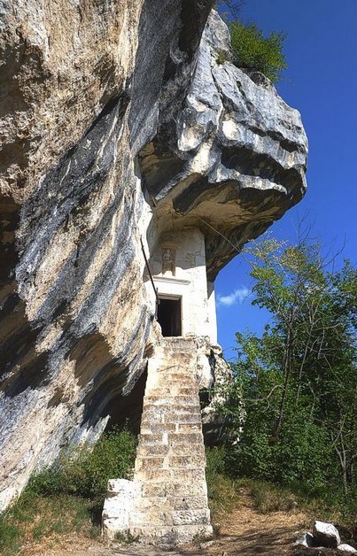 Il culto dell'Eremo di Santo Spirito a Maiella è profondamente radicato nella tradizione francescana e nella spiritualità cristiana. L'eremo, fondato nel XIII secolo, è stato per secoli un punto di riferimento spirituale per i monaci eremiti che vi si ritiravano per vivere in solitudine e preghiera. La figura di San Francesco d'Assisi, che secondo la tradizione si rifugiò in questi luoghi per dedicarsi alla meditazione e al silenzio, è al centro del culto che si sviluppò attorno all'eremo. La sua presenza, simbolica e spirituale, ha ispirato generazioni di fedeli e ha reso l'eremo un luogo di grande devozione, dove la pace e la tranquillità della natura circostante favorivano l’introspezione e la riflessione. Ogni anno, l'Eremo di Santo Spirito a Maiella ospita celebrazioni liturgiche, che sono momenti significativi di devozione per i monaci residenti e per i numerosi pellegrini che visitano il santuario. Tra i principali appuntamenti del culto, vi è la festa di San Francesco, celebrata con una messa solenne e una processione, durante la quale la comunità ricorda la figura del santo e il suo legame con questo luogo. La chiesa dell’eremo, con la sua semplicità e sobrietà, rappresenta il cuore di un culto che si nutre di spiritualità e preghiera, lontano dal rumore del mondo esterno. Il culto della Madonna, in particolare, ha una forte presenza all’interno dell’eremo. La devozione mariana è viva e diffusa tra i fedeli, che si recano al santuario per chiedere grazie o per rendere omaggio alla Madonna, invocando la sua protezione. La presenza della Madonna all'interno della chiesa dell'eremo viene anche ricordata attraverso le celebrazioni legate alla sua festa, che si tiene durante l’anno, e in occasione di pellegrinaggi speciali. La Madonna è per i fedeli una figura di speranza e di sostegno, e il culto che si svolge nell’eremo contribuisce a rafforzare la fede di chi cerca conforto e tranquillità spirituale. Oggi, l'Eremo di Santo Spirito continua a essere un luogo di culto e spiritualità che richiama non solo i monaci francescani ma anche numerosi pellegrini e visitatori. Il suo isolamento e la bellezza naturale circostante lo rendono un luogo ideale per chi cerca un contatto più profondo con la propria fede. L’eremo, infatti, non è solo un punto di riferimento per la preghiera, ma anche un simbolo di perseveranza e devozione, che incarna il percorso di vita francescano e il culto di San Francesco, sempre vivo nelle pratiche religiose del luogo. Il suo culto è, e continuerà ad essere, un'esperienza mistica e di riflessione che trascende il tempo e lo spazio.