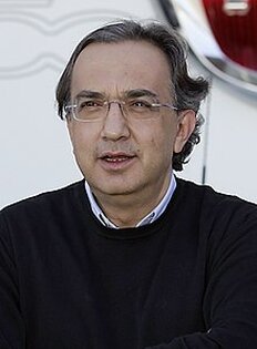 Sergio Marchionne, è stato uno degli imprenditori più significativi nella storia recente dell'industria automobilistica mondiale. Sergio Marchionne, nato a Chieti nel 1952, è stato una delle figure più significative nel panorama industriale internazionale. Dopo essersi trasferito in Canada con la sua famiglia all'età di 14 anni, Marchionne intraprese un lungo percorso di studi che lo portò a ottenere lauree in Filosofia, Giurisprudenza ed Economia. Questa preparazione accademica, unita a una mente strategica e pragmatica, lo rese pronto a affrontare le sfide più complesse del mondo degli affari. La sua carriera professionale si sviluppò in ambito finanziario e consulenziale, prima di entrare nel mondo dell'industria automobilistica, dove la sua vera ascesa ebbe inizio. Nel 2004, Marchionne fu nominato amministratore delegato del gruppo Fiat, che all'epoca stava affrontando difficoltà finanziarie significative. La sua prima mossa fu quella di razionalizzare i costi e ristrutturare l'azienda, un processo che richiese scelte drastiche e coraggiose. Con il suo approccio manageriale innovativo, riuscì a risanare i conti, incrementare la produttività e rilanciare i marchi Fiat e Lancia. La sua visione a lungo termine non si limitò al semplice risanamento: Marchionne mirava a espandere Fiat a livello internazionale, mantenendo al contempo l’attenzione sulla qualità e sull'innovazione. La sua capacità di prendere decisioni rapide e di gestire la crisi gli permise di guadagnare la fiducia del management e degli investitori. Il punto di svolta nella carriera di Marchionne arrivò con l’acquisizione di Chrysler nel 2009. La crisi economica mondiale aveva messo in difficoltà le case automobilistiche americane, e Chrysler era sull’orlo del fallimento. Marchionne, con un’intuizione da grande stratega, riconobbe l’opportunità di acquisire una quota di Chrysler, il che permetteva a Fiat di diversificare la propria offerta e accedere al mercato nordamericano. In breve tempo, Marchionne riuscì a ottenere il controllo della compagnia, unendo Fiat e Chrysler in un’unica entità globale: Fiat Chrysler Automobiles (FCA). Questo passaggio segnò una svolta epocale per Fiat, trasformandola in uno dei principali gruppi automobilistici mondiali. Parallelamente al rafforzamento di FCA, Marchionne si concentrò sul rilancio di Ferrari, uno dei marchi simbolo dell'industria automobilistica di lusso. Il suo approccio alla gestione di Ferrari fu innovativo e audace: nel 2015, sotto la sua guida, Ferrari si separò da FCA per diventare una compagnia indipendente, con una quotazione in borsa che ne aumentò ulteriormente il prestigio. Marchionne seppe trasformare Ferrari in un marchio globale di eccellenza, riuscendo a mantenerne alta la qualità artigianale e l'immagine di lusso, mentre al contempo incrementava le vendite e gli utili. La sua passione per la Formula 1 e l’attenzione al dettaglio lo portarono a rinnovare il coinvolgimento della Ferrari nel mondo delle corse, segnando un nuovo capitolo nella storia della casa automobilistica. Sergio Marchionne è stato, infine, un uomo che ha saputo combinare la capacità di innovare e risanare con un’incredibile visione internazionale. La sua eredità rimane indelebile nel mondo dell’automobile e nell'economia globale, grazie alle sue scelte coraggiose e al suo spirito di leadership. Nonostante le sfide incontrate lungo il percorso, tra cui scontri con i sindacati e le difficoltà economiche che ha dovuto affrontare, il suo approccio pragmatico e determinato gli ha permesso di cambiare radicalmente il volto dell’industria automobilistica italiana e globale. La morte prematura nel 2018 ha segnato la fine di un’era, ma il suo impatto rimarrà una pietra miliare nella storia industriale del nostro tempo.