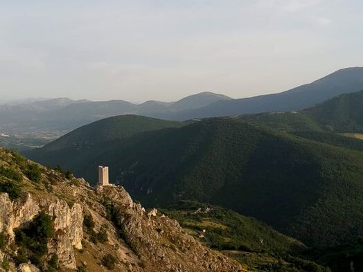 Trekking nelle valli dell’Abruzzo: La Valle dell’Aterno con la Torre di Roccapreturo. La Valle dell'Aterno si distingue per il suo paesaggio aspro e montuoso, un contrasto affascinante con la vicina e più pianeggiante Piana di Navelli. Il territorio qui è più profondo, caratterizzato da borghi pittoreschi che si arrampicano sui versanti delle montagne, dando vita a uno scenario naturale davvero suggestivo. La valle, circondata dalle imponenti montagne del Sirente e del Velino, è un luogo che sembra custodire una bellezza primordiale, in cui la natura selvaggia e i piccoli centri storici si fondono in perfetta armonia. Ogni angolo della valle racconta storie antiche, testimoniando la resistenza e l'adattamento degli abitanti alle difficoltà del territorio. Un luogo che incanta i visitatori della valle è senza dubbio le Grotte di Stiffe, una delle meraviglie naturali più spettacolari d'Abruzzo. Queste grotte, situate nel comune omonimo, sono caratterizzate dalla presenza di un fiume sotterraneo che dà vita a una cascata maestosa. Il viaggio all’interno delle grotte è un’esperienza unica, dove le acque cristalline e le formazioni rocciose creano uno spettacolo di straordinaria bellezza. La visita alle Grotte di Stiffe rappresenta una delle tappe imperdibili per chi esplora la Valle dell’Aterno, aggiungendo un tocco di mistero e fascino alla già ricca offerta di natura e storia. Lungo il cammino, ci si può addentrare nei borghi di Fontecchio e Tione degli Abruzzi, che offrono l’opportunità di un viaggio nel passato. In questi luoghi si possono ancora ammirare le antiche "pagliare", i rifugi dei pastori costruiti con pietra e paglia. Questi villaggi di montagna, testimoni di tradizioni secolari, sono strettamente legati alla vita rurale della valle. Passeggiando tra le viuzze di Fontecchio e Tione, si respira un’atmosfera di pace e di connessione con la natura che, pur essendo lontana dai ritmi frenetici della vita moderna, sembra raccontare le storie di chi ha abitato queste terre da generazioni. Raggiungere Secinaro, un piccolo borgo immerso nel cuore del massiccio del Sirente-Velino, segna l'ingresso in un mondo dove la natura regna sovrana. Questo paesino rappresenta il punto di partenza ideale per escursioni e trekking nei sentieri che risalgono il massiccio, offrendo panorami incredibili. Qui, tra vette imponenti e boschi rigogliosi, gli escursionisti possono immergersi in una natura incontaminata e godere di un’atmosfera di tranquillità che sembra avvolgere l’intera valle. La Valle dell’Aterno, con i suoi borghi autentici e la natura selvaggia, è una destinazione ideale per chi cerca un’esperienza di trekking che coniughi storia, natura e tradizioni locali.