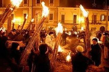 L’Accensione dei Faugni ad Atri, in provincia di Teramo, è una delle manifestazioni più antiche e suggestive dell’Abruzzo, un rito che affonda le sue radici in epoche lontane, intrecciando tradizione pagana e devozione cristiana. Il termine "faugni" deriva dal latino fauni ignis, ovvero "fuoco di Fauno", e richiama antichi riti agricoli legati al solstizio d’inverno e alla fertilità della terra. Con l’avvento del Cristianesimo, questo culto arcaico si è trasformato in una celebrazione dedicata all’Immacolata Concezione, mantenendo intatta la magia del fuoco come simbolo di rinnovamento e purificazione. La notte tra il 7 e l’8 dicembre è il momento più atteso, quando la città ducale si anima in un’atmosfera unica di festa e spiritualità. La vigilia, conosciuta come "La Notte dei Faugni", è caratterizzata da veglie nelle case e nelle taverne, tra cene tradizionali e momenti di convivialità che coinvolgono tutta la comunità. Le strade si riempiono di suoni e colori, con concerti, spettacoli e iniziative che accompagnano il lungo viaggio verso l’alba, in un crescendo di emozioni che culmina con l’accensione dei fasci di canne. Allo spuntare del giorno, il rito prende vita. I faugni, alti fasci di canne secche legati insieme, vengono accesi e portati in processione per le vie del centro storico. Il corteo sfila tra le antiche strade di Atri, illuminato dal bagliore delle fiamme e accompagnato dalle note solenni della banda musicale. Il fuoco che arde rappresenta la purificazione e la continuità con il passato, un legame profondo tra gli uomini e la spiritualità, tra la comunità e la sua storia. Oltre alla dimensione rituale, la festa è un momento di forte aggregazione sociale. La partecipazione è ampia e sentita, coinvolgendo non solo gli abitanti di Atri, ma anche numerosi visitatori attratti dal fascino di un evento che conserva il suo antico spirito. Mostre, spettacoli teatrali e degustazioni di prodotti tipici arricchiscono l’esperienza, trasformando la celebrazione in un’occasione per riscoprire le radici culturali del territorio e il calore della tradizione abruzzese. L’Accensione dei Faugni non è solo un rito folcloristico, ma un’esperienza che unisce passato e presente, fede e socialità, sacro e profano. Il fuoco che brucia all’alba dell’8 dicembre è il cuore pulsante di una comunità che continua a tramandare la propria identità, mantenendo vivo uno dei riti più affascinanti dell’Abruzzo. Questa celebrazione è un simbolo di appartenenza, un legame che, anno dopo anno, continua a illuminare le strade di Atri e a scaldare l’anima di chi vi partecipa.