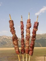 Gli arrosticini abruzzesi Gli arrosticini sono uno dei simboli gastronomici più amati dell'Abruzzo, un piatto che racconta la tradizione pastorale e l’identità di questa regione. Questi spiedini di carne ovina, tipicamente preparati con tagli di pecora o agnello, vengono realizzati con cura per ottenere piccoli bocconcini infilzati su stecchi di legno. La cottura avviene su una griglia stretta e lunga, detta "canala", che permette di arrostire la carne lentamente e in modo uniforme, conferendole il suo caratteristico sapore affumicato e irresistibile. Originariamente consumati dai pastori durante le transumanze, gli arrosticini sono oggi protagonisti di conviviali momenti di festa e ritrovo, sia nelle famiglie che nelle sagre locali. Spesso accompagnati da pane casereccio e un filo d'olio extravergine d'oliva, si gustano meglio in abbinamento ai vini locali, come il Montepulciano d'Abruzzo. Questo piatto semplice ma ricco di tradizione continua a essere un elemento di orgoglio regionale, capace di conquistare chiunque assapori l’Abruzzo attraverso i suoi sapori autentici. Gli arrosticini rappresentano uno dei simboli più iconici della cucina abruzzese, un piatto semplice ma profondamente radicato nella tradizione pastorale della regione. Questi spiedini di carne ovina, tipicamente ricavati da tagli alternati di polpa e grasso per esaltare sapore e morbidezza, vengono cotti su una caratteristica griglia lunga e stretta chiamata “furnacella”. La preparazione è essenziale, senza l’aggiunta di condimenti se non un pizzico di sale, lasciando che il gusto autentico della carne emerga in tutta la sua intensità. Da sempre associati ai momenti conviviali, gli arrosticini si consumano caldi, appena tolti dalla brace, spesso accompagnati da pane casereccio bagnato con olio d’oliva e da un bicchiere di vino Montepulciano d’Abruzzo. Originari delle zone interne della regione, gli arrosticini si sono rapidamente diffusi in tutta l’Abruzzo e oltre, diventando un emblema della cultura gastronomica locale. Sono più di un piatto: sono un rito collettivo, un momento di condivisione che racconta il legame tra il cibo e l’identità del territorio.