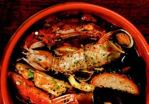 Il brodetto alla giuliase. Il brodetto alla giuliese è un piatto simbolo della tradizione marinara di Giulianova, in Abruzzo, che celebra la ricchezza del mare Adriatico. Questa preparazione antica si distingue per l'armonia di sapori che nasce dall'utilizzo di diversi tipi di pesce freschissimo, tra cui merluzzi, triglie, seppie, scampi e cozze. La ricetta segue rigorosamente il ciclo delle stagioni, impiegando ciò che il mare offre in quel momento, e si basa su ingredienti semplici ma sapientemente bilanciati, come olio extravergine di oliva, pomodori maturi, aglio, peperoncino e prezzemolo.