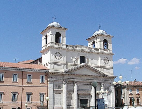 Cattedrale metropolitana dei Santi Massimo e Giorgio martiri a L’Aquila La Cattedrale metropolitana dei Santi Massimo e Giorgio martiri, situata nel cuore della città dell'Aquila, è uno degli edifici religiosi più significativi dell'Abruzzo. La cattedrale, che rappresenta il centro spirituale della diocesi aquilana, è dedicata ai santi patroni della città, Massimo e Giorgio, martiri cristiani venerati sin dai primi secoli del cristianesimo. La sua posizione, nel centro storico, la rende un punto di riferimento religioso e culturale per la comunità locale e per i visitatori. La cattedrale ha una storia che risale al VI secolo, ma l'edificio attuale fu costruito principalmente tra il XII e il XIII secolo, con rimaneggiamenti successivi che si sono susseguiti nei secoli. Nel corso della sua lunga storia, la cattedrale ha subito diversi danni a causa di eventi catastrofici, tra cui il devastante terremoto del 1703 che causò gravi danni strutturali. Dopo quel disastro, l'edificio fu ricostruito con elementi barocchi, che arricchirono l'aspetto della chiesa, ma mantenendo alcuni tratti tipici dello stile romanico. Nel corso degli anni, la cattedrale ha continuato a evolversi e a essere al centro della vita religiosa e civile della città. Fu elevata a cattedrale metropolitana nel 1930, quando la diocesi dell'Aquila fu costituita come metropolia. Questo ha contribuito ad accrescerne l'importanza come centro religioso e culturale, non solo per la città dell'Aquila, ma anche per l'intera regione. Nel 2009, la cattedrale fu gravemente danneggiata dal devastante terremoto che colpì L'Aquila. Tuttavia, grazie a un importante intervento di restauro, che ha permesso di ripristinare gran parte delle strutture originali, la cattedrale è tornata a essere un simbolo di speranza e di resilienza per la città. Oggi, la Cattedrale metropolitana dei Santi Massimo e Giorgio martiri continua a essere un luogo di culto, di riflessione spirituale e un’importante attrazione turistica per chi visita la città dell'Aquila.