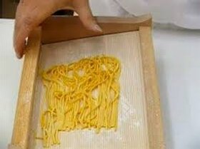 I maccheroni alla chitarra sono il primo piatto per eccellenza in tutte le tavole dell’Abruzzo. Sono deliziosi spaghetti a sezione quadrata di 2 millimetri; potrebbero ricordare le fettuccine ma in realtà sono più spessi e meno larghi. L’impasto è quello classico delle paste fresche, a base di farina e uova. Devono la loro particolarità alla tecnica di preparazione da cui prendono il nome o, meglio, dallo strumento con cui viene tagliato l’impasto. La “chitarra”, infatti, è una sorta di telaio di legno rettangolare, composto da fili d’acciaio disposti parallelamente: si chiama così perché le corde metalliche ricordano quelle dello strumento musicale. I fili vengono disposti a una distanza di 2-3 millimetri l’uno dall’altro e, una volta adagiata sopra la sfoglia che non deve essere troppo sottile viene pressata col mattarello per formare degli spaghetti quadrati, ovvero i maccheroni alla chitarra. Il primo prototipo della “chitarra maccarunare” risale al 1860, dopo l’introduzione in Italia del filo d’acciaio proveniente dalla Germania, da parte dei “setacciari” per aiutare le massaie a tagliare la pasta. I setacciari erano i costruttori di setacci per la farina, un mestiere oggi scomparso. Il filo di acciaio si diffuse così tanto da essere inserito nel necessario da acquistare per il corredo delle spose abruzzesi e veniva chiamato in dialetto il “carrature”, ovvero “carratore per pasta”, un termine che deriva dal francese “carrer” che significa tagliare a quadretti.