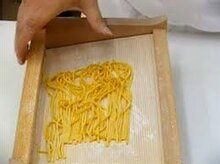 Gli spaghetti alla chitarra, o maccheroni alla chitarra, sono un formato di pasta all’uovo a sezione quadrata, tipico della cucina abruzzese. Sono diffusi anche in altre zone dell’Italia centro-meridionale, con nomi diversi e piccole variazioni nella ricetta, come i tonnarelli nel Lazio, leggermente più spessi, e i cirioli in Molise. Si tratta di una pasta fresca preparata impastando insieme la semola di grano duro con uova freschissime e un pizzico di sale. Una volta ottenuto un composto liscio e omogeneo, questo, dopo un tempo di riposo, viene steso in uno strato sottile, a mano o con la macchinetta sfogliatrice, e poi appoggiato sulla chitarra: l’apposito utensile a corde utilizzato per confezionare la pasta. A questo punto, non ti rimarrà che formare gli spaghetti passando delicatamente un matterello avanti e indietro sulla sfoglia, e trasferirli poi su un tagliere cosparso con un po' di farina. Niente di più facile insomma, a patto, naturalmente, di disporre degli strumenti giusti. Una volta pronti, grazie alla loro consistenza ruvida e porosa, gli spaghetti si prestano a essere conditi con ragù corposi, come quello alla bolognese, o con le pallottine, piccole polpettine di manzo. Per una riuscita ottimale non dimenticare di controllare che tutte le corde della chitarra siano “accordate”, ovvero che risultino perfettamente dritte e ben tese, e che non siano fuoriuscite dalle guide: in caso contrario ti consigliamo di perdere qualche minuto a sistemarle, per ottenere dei maccheroni doc. Scopri come preparare gli spaghetti alla chitarra seguendo passo passo procedimento e consigli. Se ti è piaciuta questa ricetta, prova anche altri piatti tipici abruzzesi. In una ciotola capiente, disponi la farina a fontana, rompi al centro le uova 1 e aggiungi un pizzico di sale.