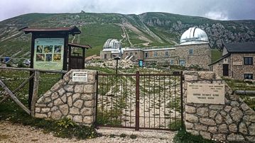 Il Giardino Alpino di Campo Imperatore, situato a 2.117 metri di altitudine nel Parco Nazionale del Gran Sasso e Monti della Laga, ospita una flora che testimonia la straordinaria biodiversità montana, con piante adattate a condizioni climatiche particolarmente severe. La flora extra mediterranea che popola questo giardino è il risultato di una combinazione di fattori naturali, come la forte escursione termica e i venti intensi, che caratterizzano le montagne appenniniche. Queste piante, per la maggior parte erbacee, si sono adattate a vivere in un ambiente in cui la vegetazione arborea è praticamente assente e solo le specie più resistenti riescono a prosperare. Le specie che compongono la flora extra mediterranea del giardino sono particolarmente affascinanti per la loro capacità di adattamento. Piante come l'Arenaria villosa, la Silene acaulis e la Campanula cenisia sono esempi di flora che cresce in condizioni difficili, come su rocce o ghiaioni, dove la scarsità di acqua e il terreno poco fertile richiedono a queste specie di sviluppare particolari strategie di sopravvivenza. Queste piante, con le loro radici profonde e il loro portamento cespuglioso, resistono ai venti gelidi e ai periodi di siccità, mostrando una grande resilienza. Il giardino, con le sue diverse aree ecologiche, ospita anche numerose specie endemiche delle zone alpine e subalpine, molte delle quali si trovano solo in specifici ambienti montani. Tra queste, alcune piante appartengono a famiglie botaniche rare, come le Ericaceae, che prosperano in terreni acidi e ben drenati, come quelli che si trovano nelle zone di alta quota. Altre specie, come il Rhododendron ferrugineum, sono caratteristiche di ambienti umidi e freschi, tipici delle zone alpine, dove la neve permane a lungo e l’umidità è elevata. Inoltre, la flora extra mediterranea del giardino comprende una vasta gamma di piante alpine che appartengono a diversi tipi di habitat. Le piante che colonizzano le zone di alta montagna si adattano a condizioni difficili, come la forte esposizione al sole, le temperature rigide e le estati brevi. La Draba, la Gentiana, e l’Edelweiss sono esempi di piante che si trovano in ambienti rupestri e ghiaiosi, dove la resistenza alla scarsità di nutrienti e alla forte esposizione alle intemperie è essenziale per la loro sopravvivenza. Infine, il Giardino Alpino di Campo Imperatore non solo conserva queste specie rare e vulnerabili, ma svolge anche un’importante funzione di ricerca scientifica. La sua posizione unica e la varietà di specie che ospita lo rendono un laboratorio naturale per lo studio della biodiversità alpina e dei meccanismi di adattamento delle piante alle condizioni più estreme. I visitatori hanno l’opportunità di ammirare non solo la bellezza naturale di queste piante, ma anche di comprendere il delicato equilibrio ecologico che consente loro di prosperare in ambienti così estremi, rendendo il giardino un punto di riferimento per la conservazione delle piante alpine.